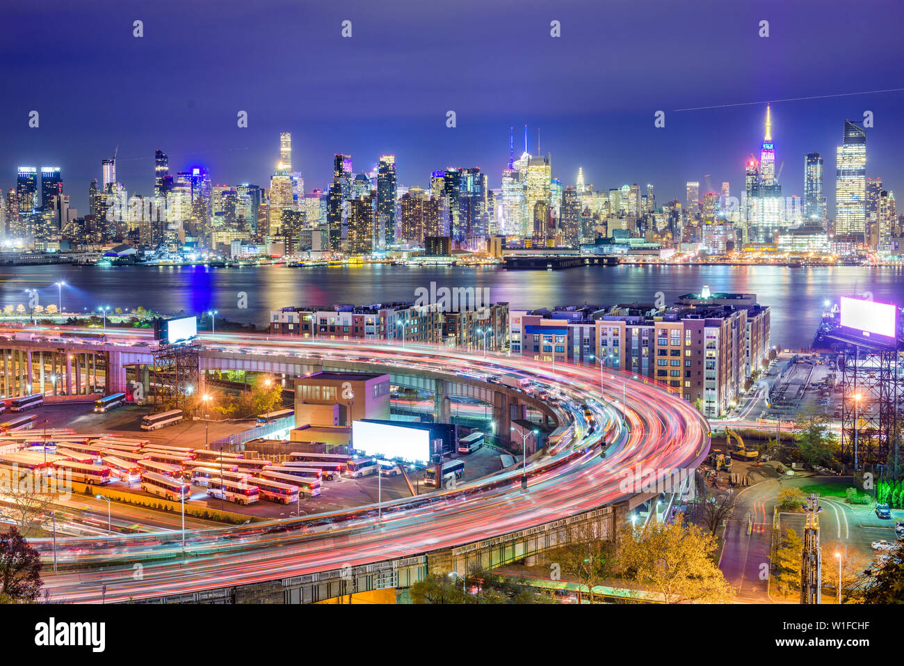 New York, New York, Stati Uniti d'America cityscape e autostrade da attraverso il Fiume Hudson di notte. Foto Stock