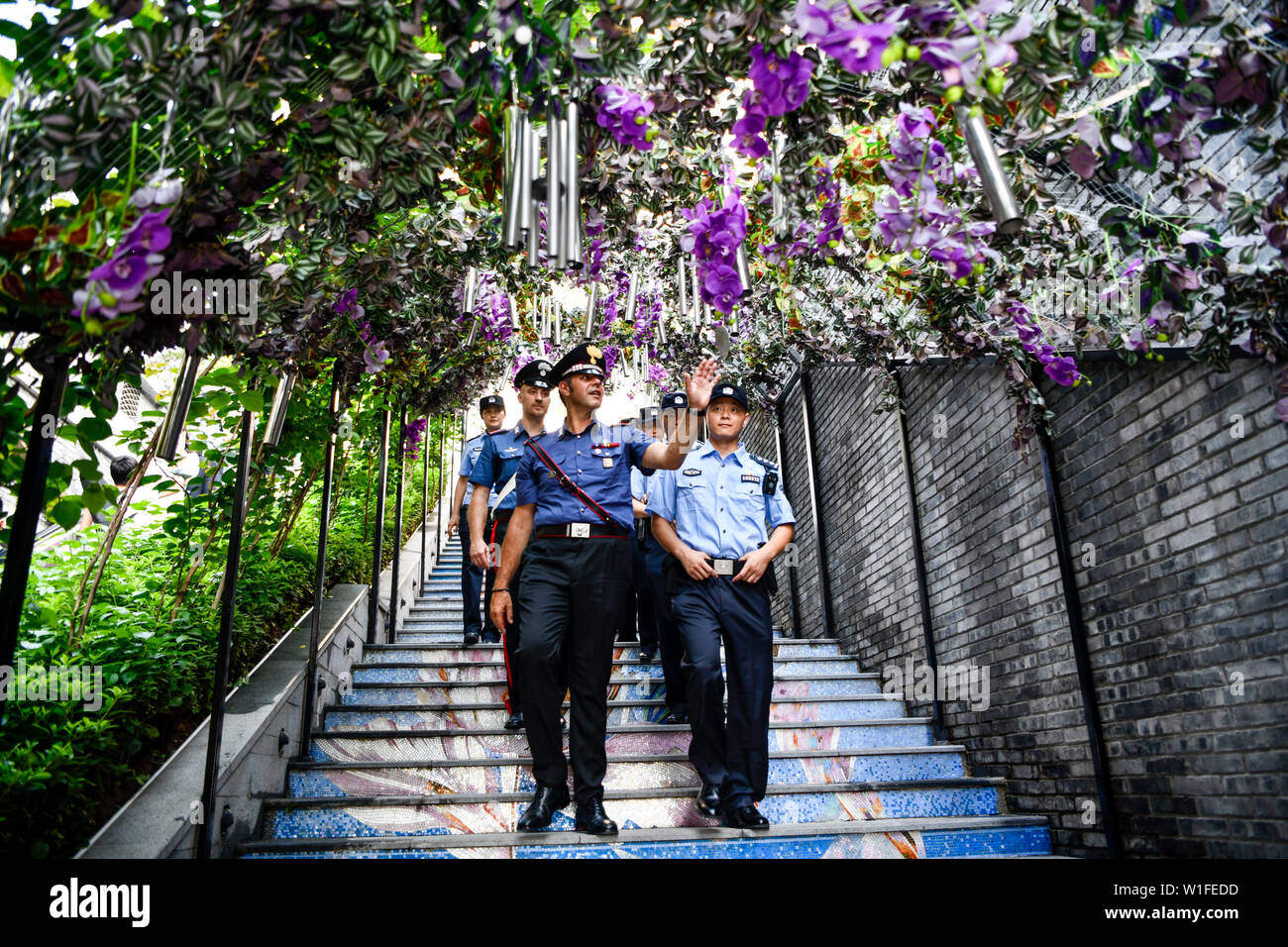 (190702) -- CHONGQING, 2 luglio 2019 (Xinhua) -- Cinese e Italiano degli ufficiali di polizia pattuglia a una vecchia strada di Nan An distretto del sud-ovest della Cina della Municipalità di Chongqing, 2 luglio 2019. La polizia di Chongqing ha lanciato un pattugliamento comune con le loro controparti italiane il 26 giugno, secondo la polizia locale. Quattro poliziotti cinesi che erano fluente in inglese e italiano hanno aderito la pattuglia con due italiani ufficiali della polizia. Il pattugliamento di famose mete turistiche in comune, la polizia italiana funzionari potranno aiutare a trattare le questioni legate ai turisti italiani durante i dieci giorni di pattugliamento comune. Foto Stock
