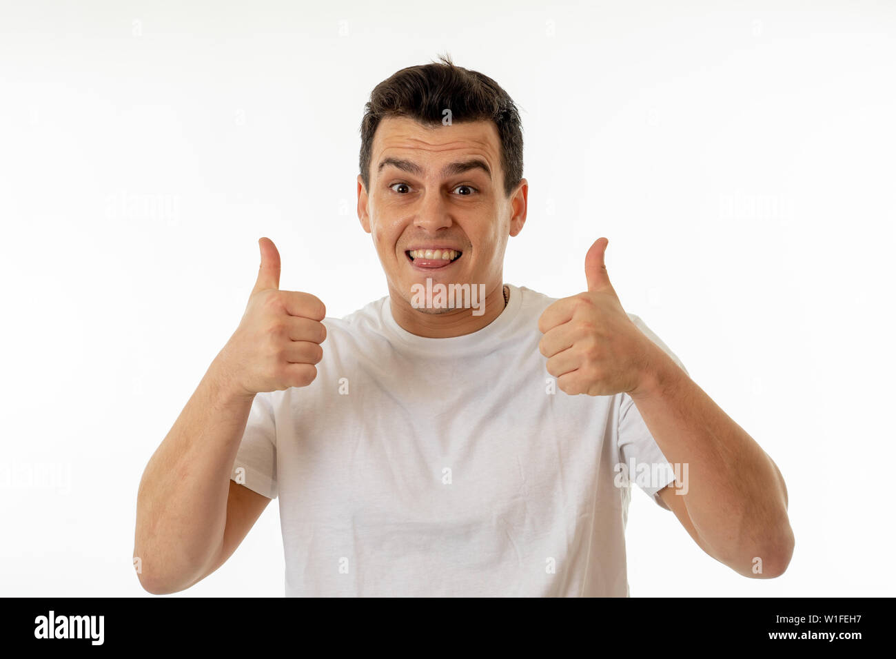 Close up ritratto di Giovane uomo caucasico con un buon viso e sorriso bellissimo che mostra la vittoria gesti. Isolato su sfondo bianco. In Persone, Posi Foto Stock