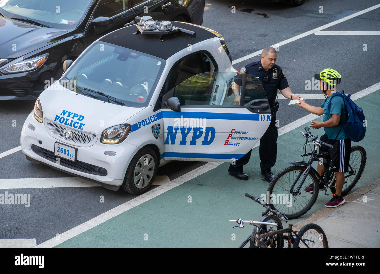 Ufficiali di NYPD emettere un biglietto per un ciclista per un non meglio specificato infrazione in bicicletta lane sulla Nona Avenue nel quartiere di Chelsea di New York il Giovedì 27 Giugno, 2019. (© Richard B. Levine) Foto Stock