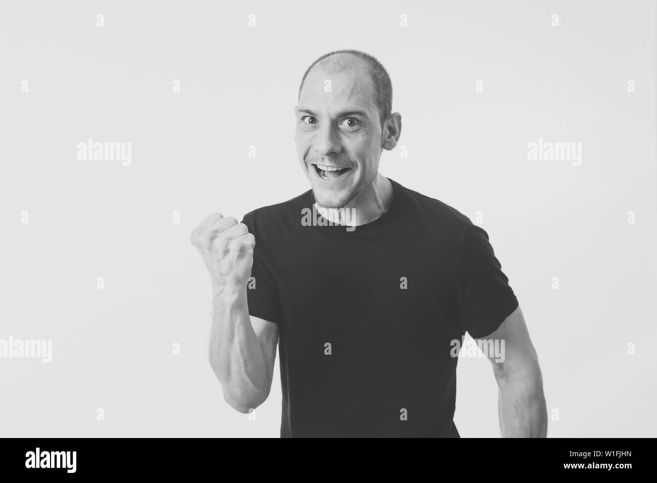 Faccia felice e le espressioni del viso in persone e le emozioni umane. Mezza lunghezza Ritratto di sorridente giovane adulto uomo eccitato gesticolando e celebrando vict Foto Stock