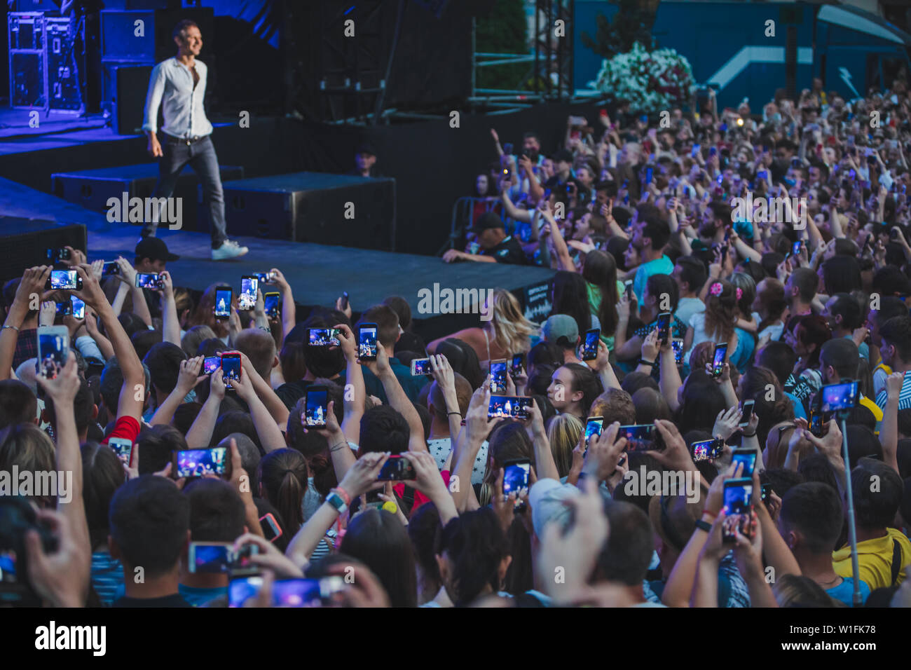 LVIV, Ucraina - 18 Giugno 2019: rock band cantante sul palco con microfono si affollano intorno Stadio riprese su telefoni. music fest Foto Stock