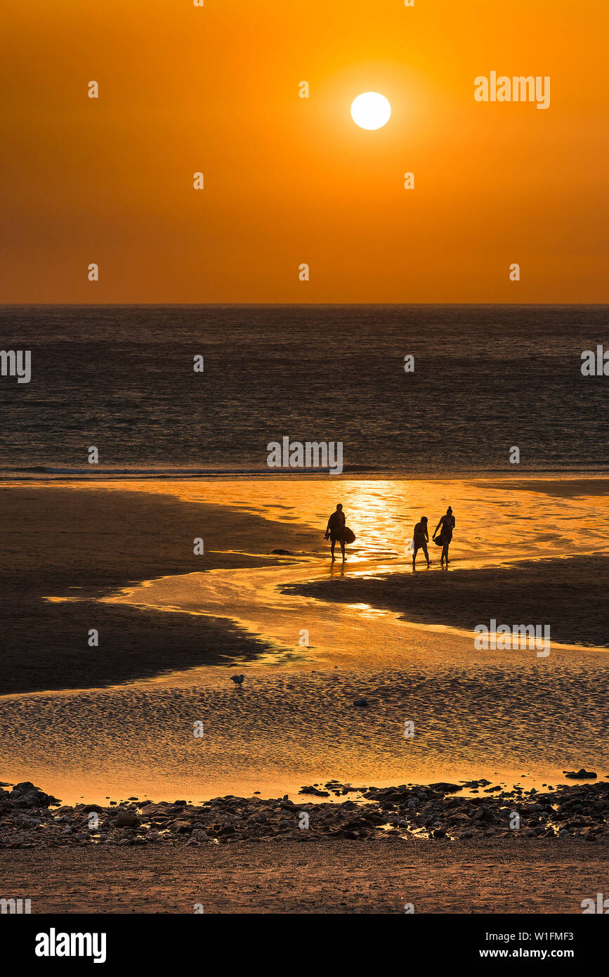 La gente vede in silhouette come un bel tramonto imposta su Fistral Beach in Newquay in Cornovaglia. Foto Stock