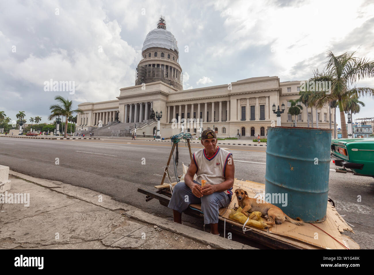 L'Avana, Cuba - 14 Maggio 2019: uomo cubano con un cane per le strade vista della bella e antica città dell'Avana, capitale di Cuba, durante una luminosa e soleggiata giornata Foto Stock