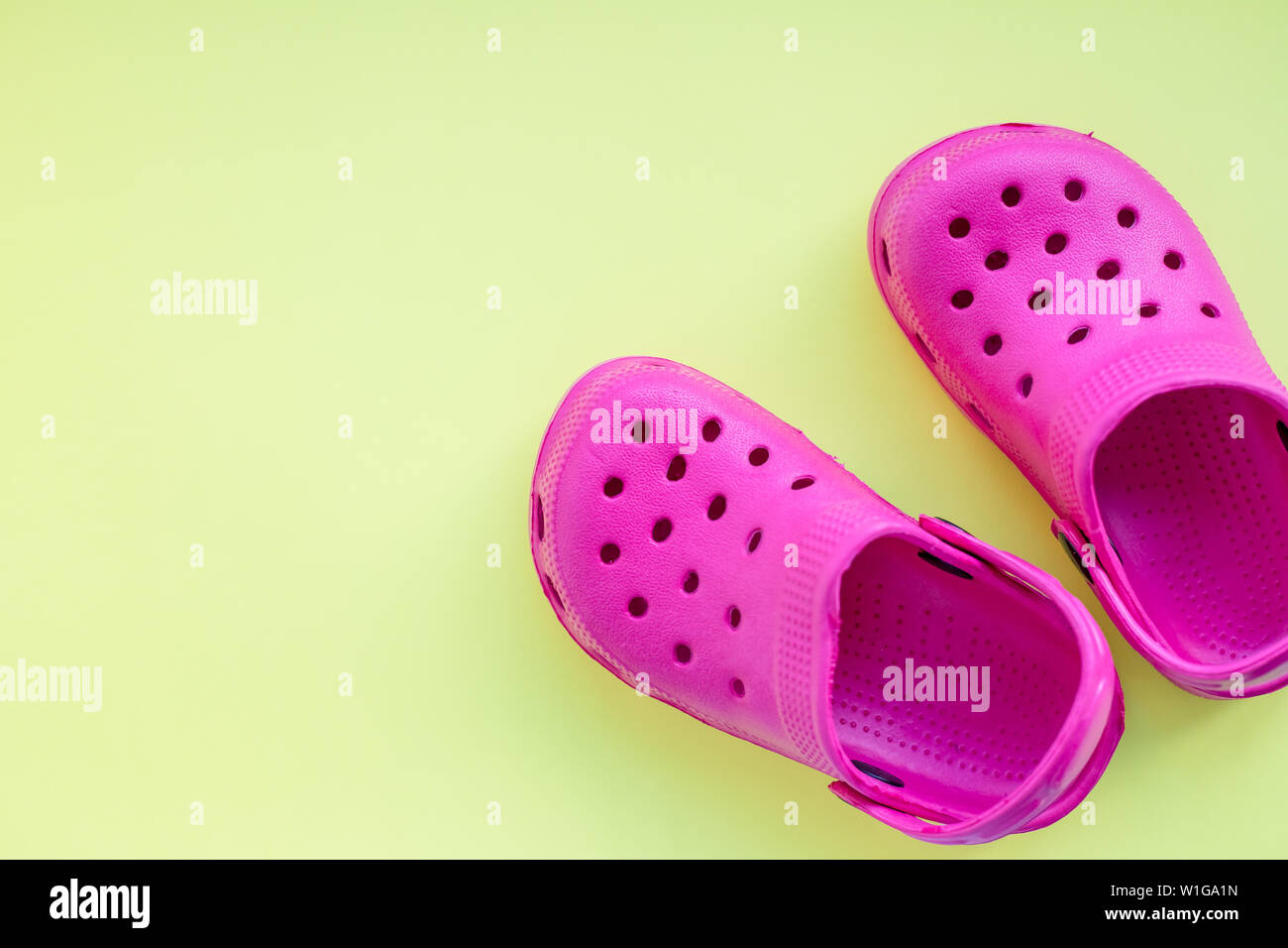 San Diego, Stati Uniti d'America,10 Maggio 2019.Estate rosa flip flop  isolato su sfondo giallo. Bambini in gomma morbida o sandali Crocs.vacanze  estive Scarpe alla moda Foto stock - Alamy