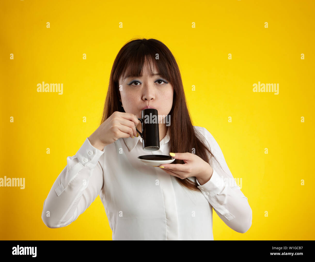 Donna asiatica di bere dalla tazza di espresso Foto Stock