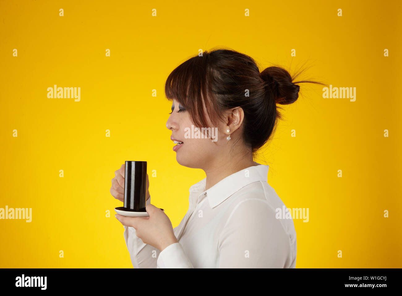 Donna asiatica di bere dalla tazza di espresso Foto Stock