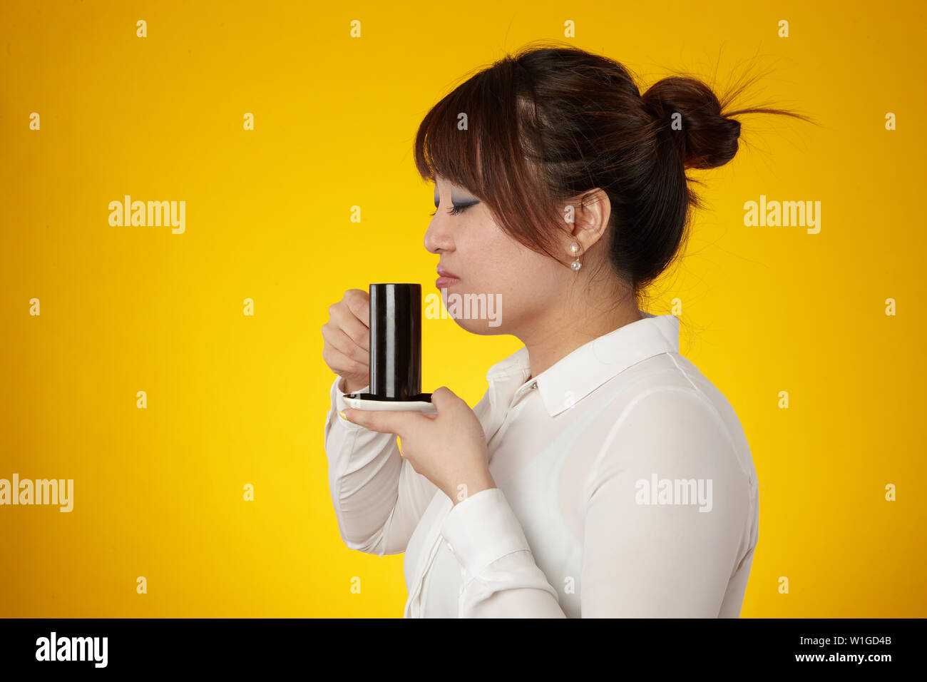 Donna asiatica di bere dalla tazza di espresso Foto Stock