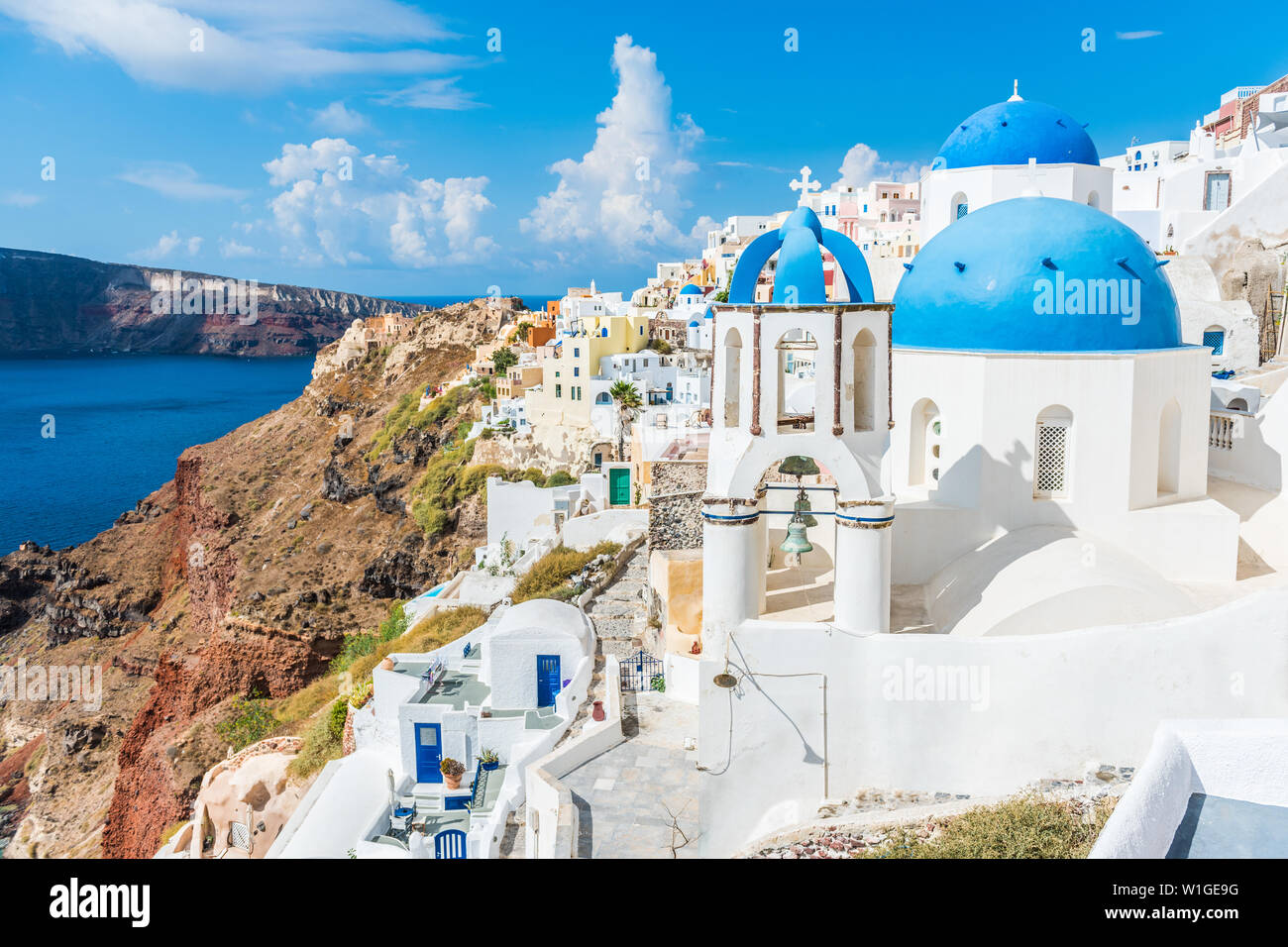 Grecia turistica famosa destinazione di viaggio Santorini isola greca. Tre cupole blu. Estate popolare di lusso vacanze crociera Europa stop. Strade di europeo villaggio bianco con il mare mediterraneo. Foto Stock