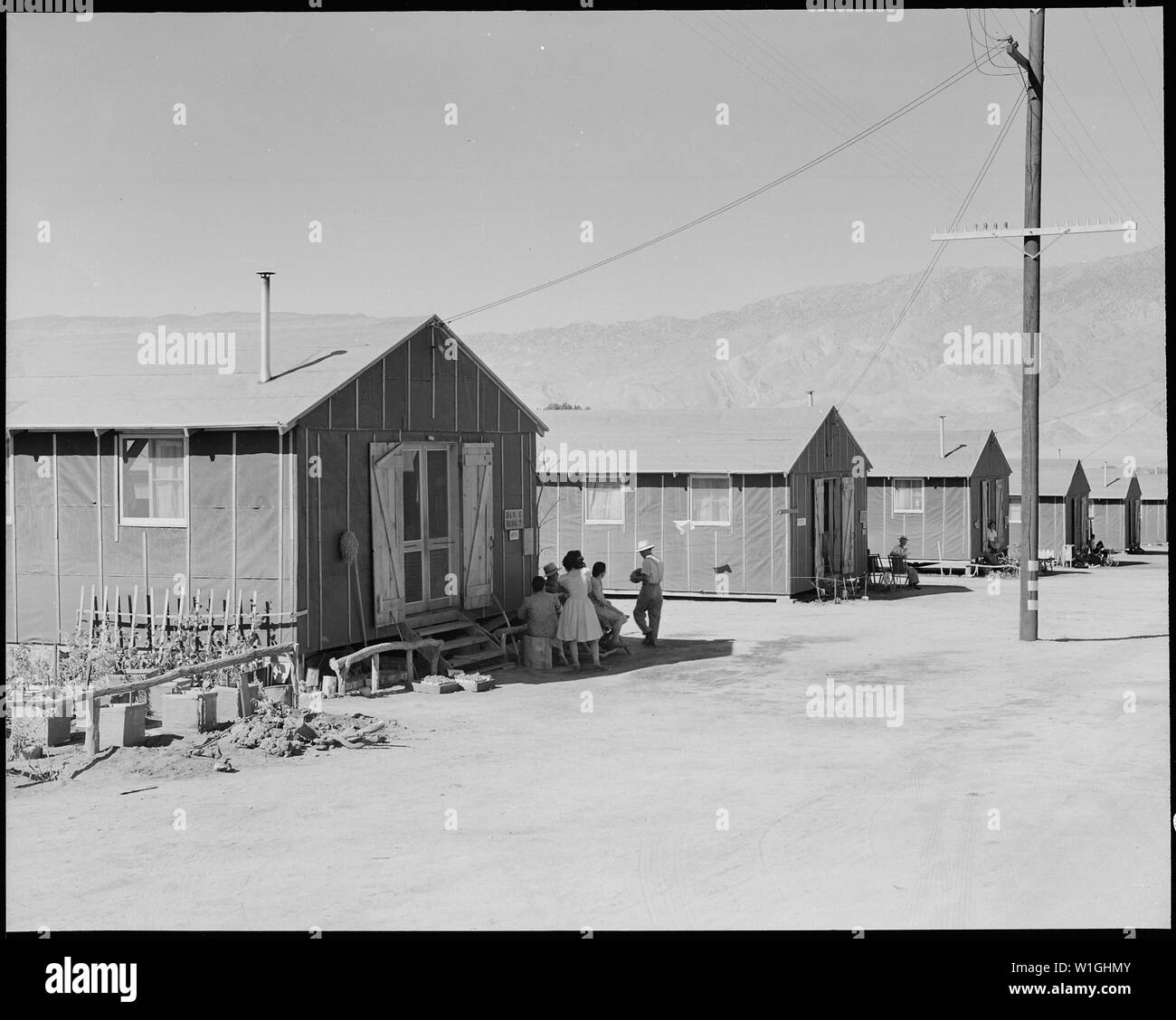 Manzanar Relocation Center, Manzanar, California. Barrack case di questa guerra Relocaton competente cen . . .; Portata e contenuto: tutta la didascalia per questa fotografia si legge: Manzanar Relocation Center, Manzanar, California. Barrack case di questa guerra Relocaton competente centro. La famiglia in primo piano hanno iniziato un fiore in giardino per fare i loro dintorni più home-like. Foto Stock