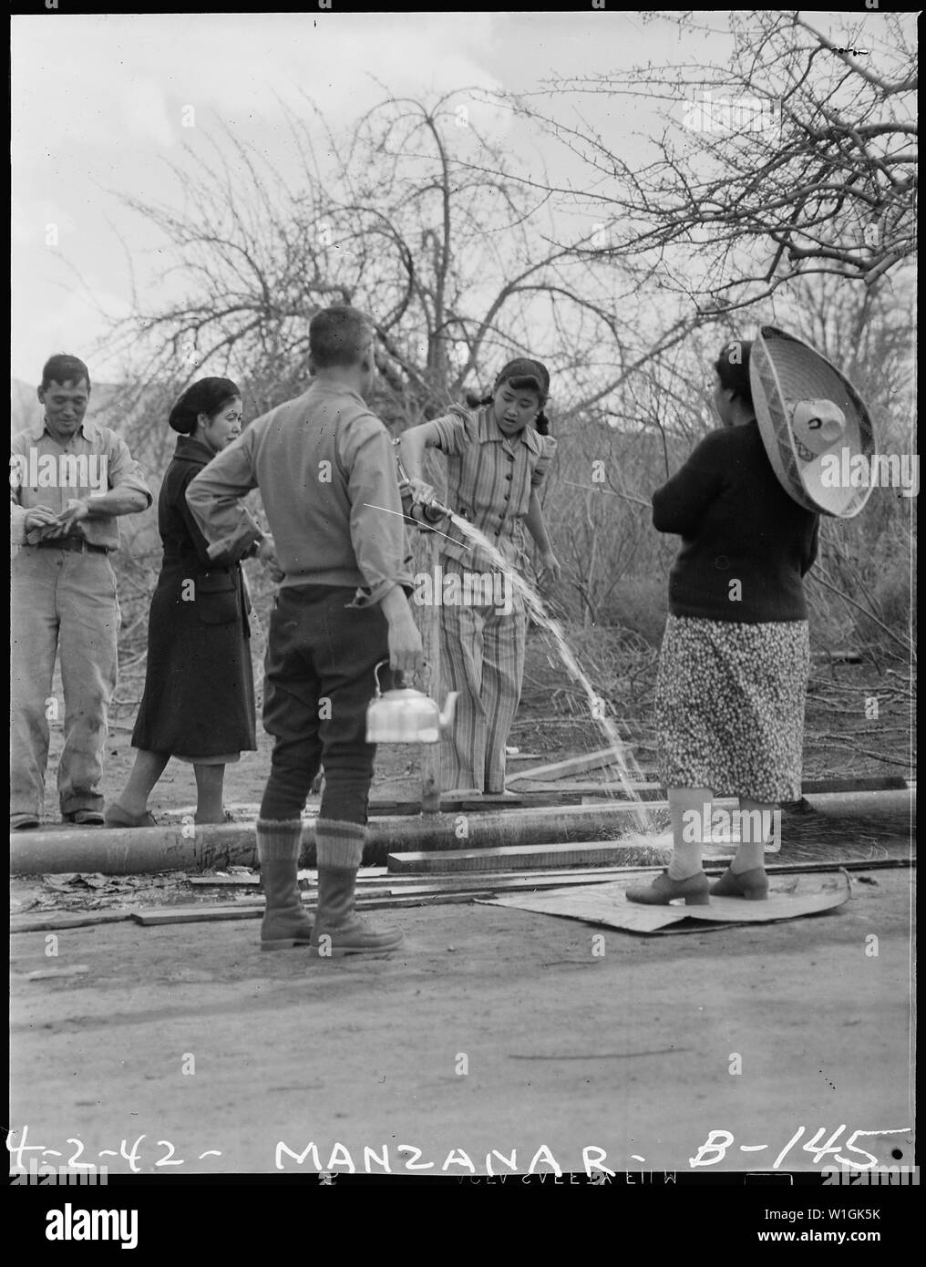 Manzanar Relocation Center, Manzanar, California. I residenti del Centro Manzanar sono mostrati waitin . . .; Portata e contenuto: tutta la didascalia per questa fotografia si legge: Manzanar Relocation Center, Manzanar, California. I residenti del Centro Manzanar sono mostrati in attesa presso l'idrante di acqua per acqua per la loro baracca appartamenti. Foto Stock