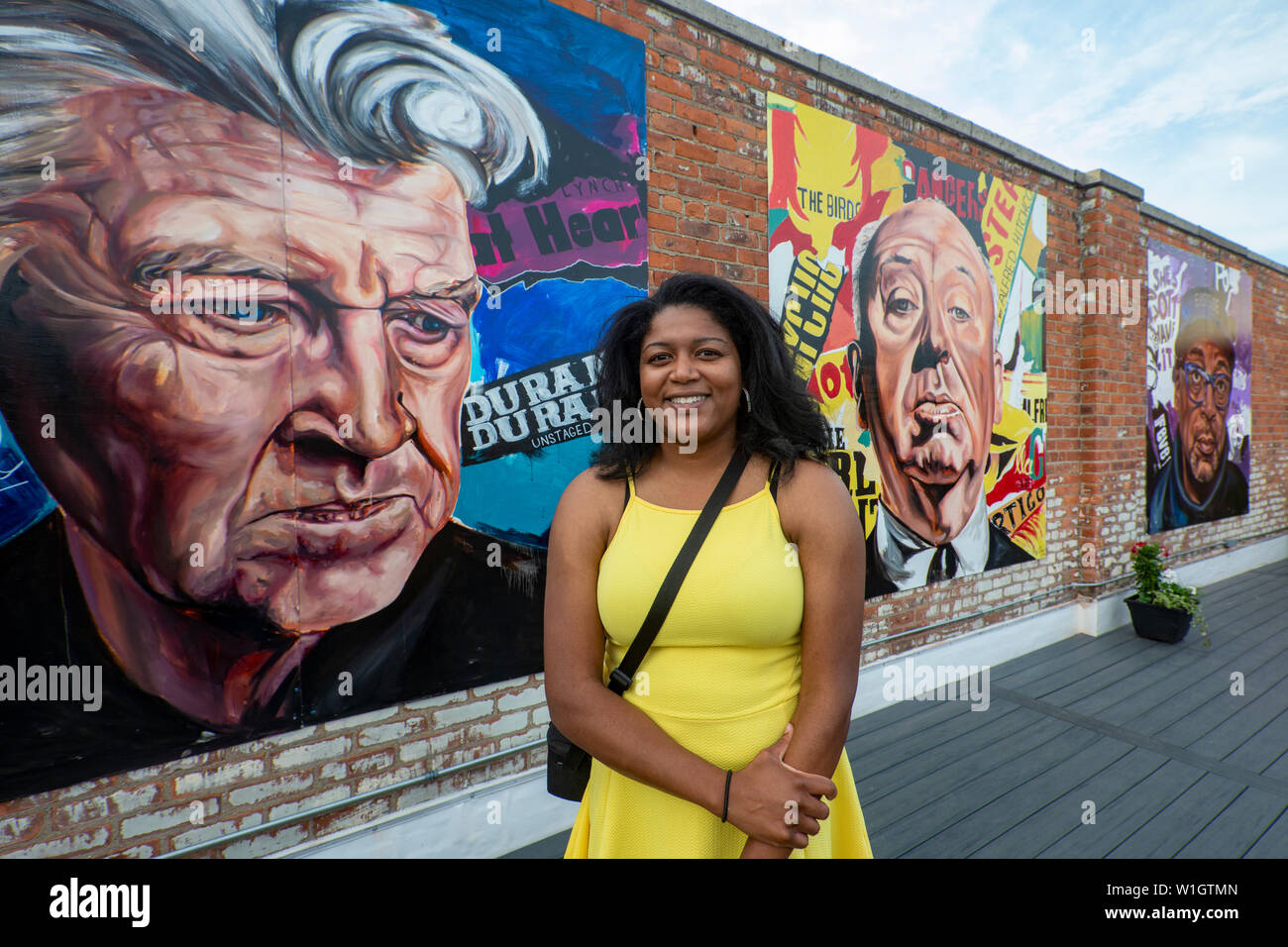 Detroit, Michigan - l'artista Desiree Kelly il patio sul tetto dell'Alger Theatre, con tre dei suoi dipinti, che mostra David Lynch, Alfred il sollevatore Foto Stock