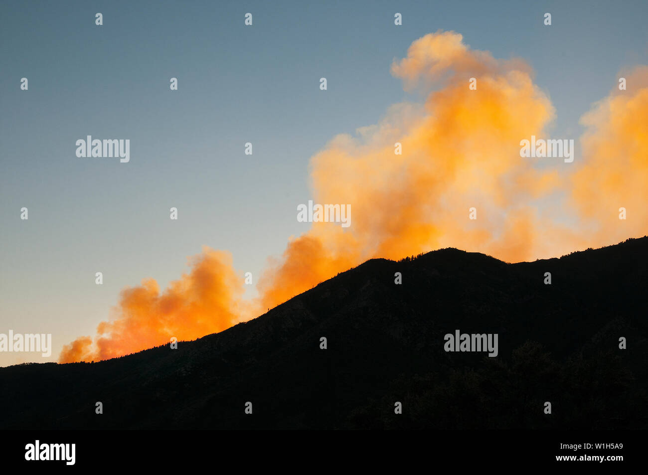 Arancio brillante flutti di fumo nel Cielo di tramonto dal fuoco di quaglia in Alpine, Utah come visto dal versante orientale delle Wasatch Range. (C) 2012 Tom Foto Stock