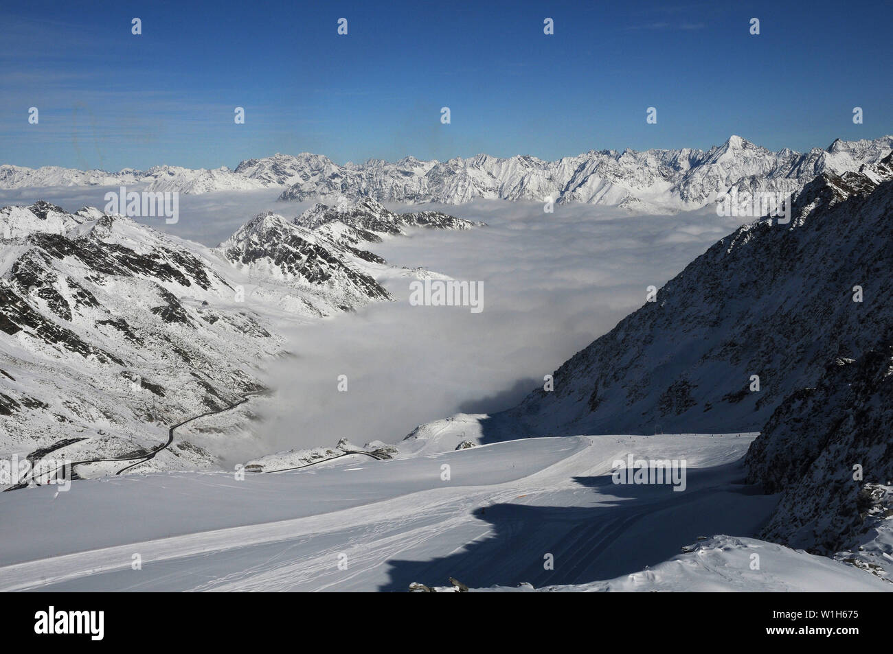 Pillowy nuvole coperta la valle tirolese imponenti cime alpine anello l'area attorno a Soelden, Austria come si vede dal ghiacciaio Rettenbach. (C) 200 Foto Stock