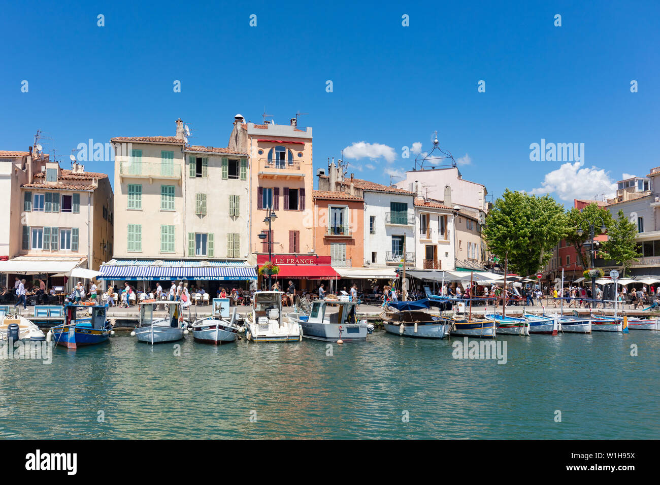Cassis, Francia; 22 giugno 2019; linea di imbarcazioni ormeggiate con i suoi edifici colorati dietro Foto Stock