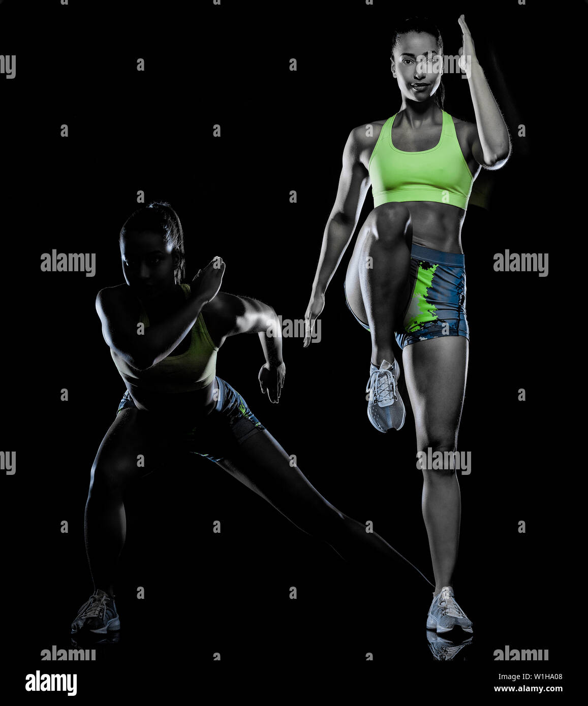 Una razza mista donna esercizio esercizi fitness isolati su sfondo nero con effetto lightpainting esposizioni multiple Foto Stock