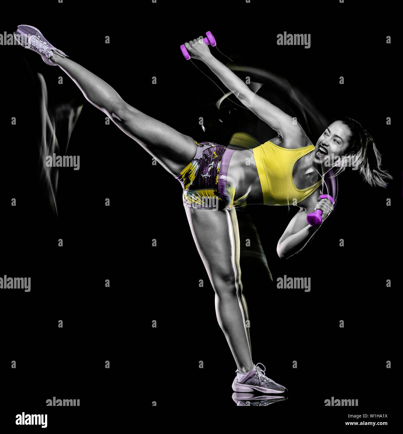 Una razza mista donna esercizio esercizi fitness isolati su sfondo nero con effetto lightpainting Foto Stock