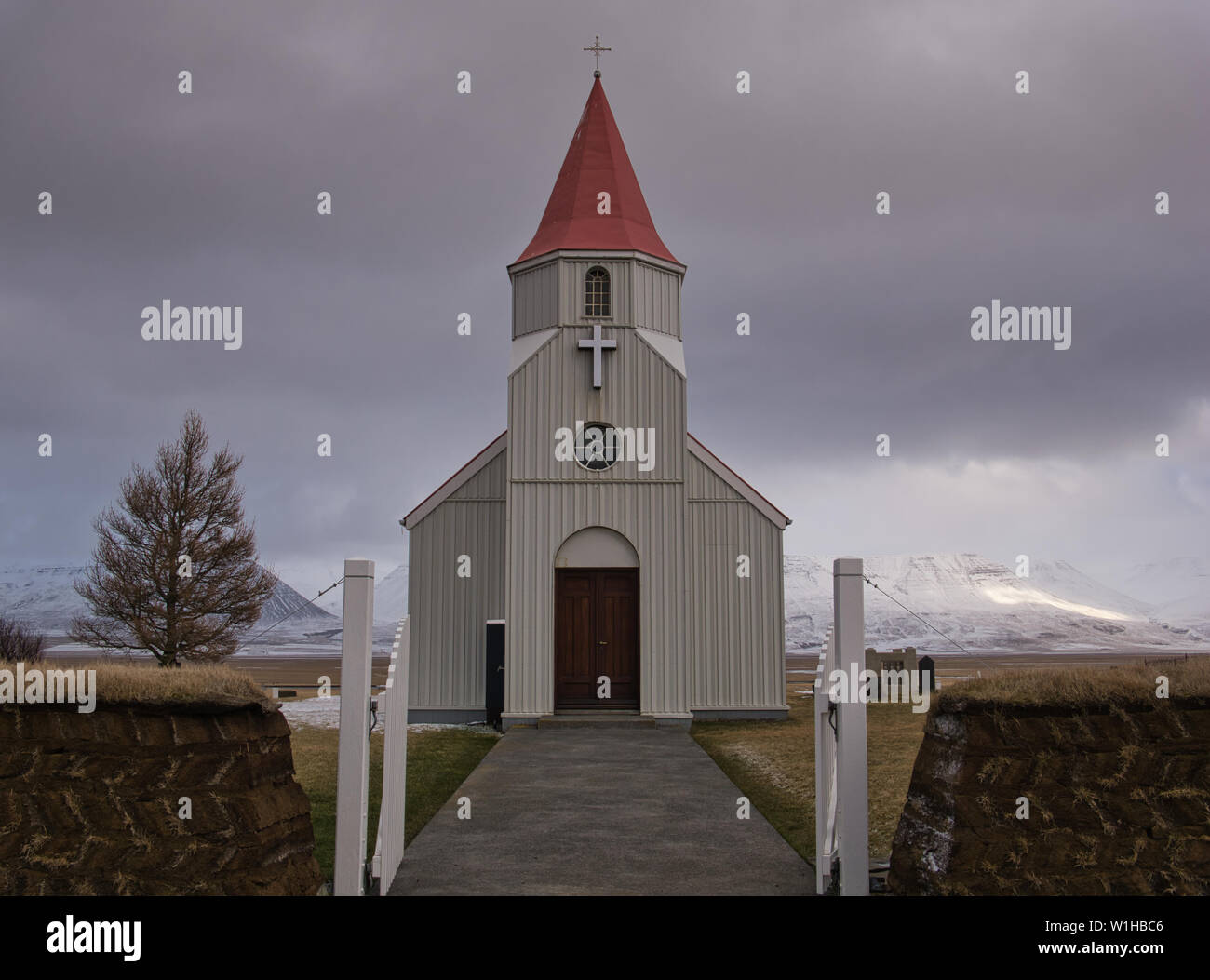 Un tipico di torba nella parete anteriore di una piccola chiesa bianca in Islanda Foto Stock