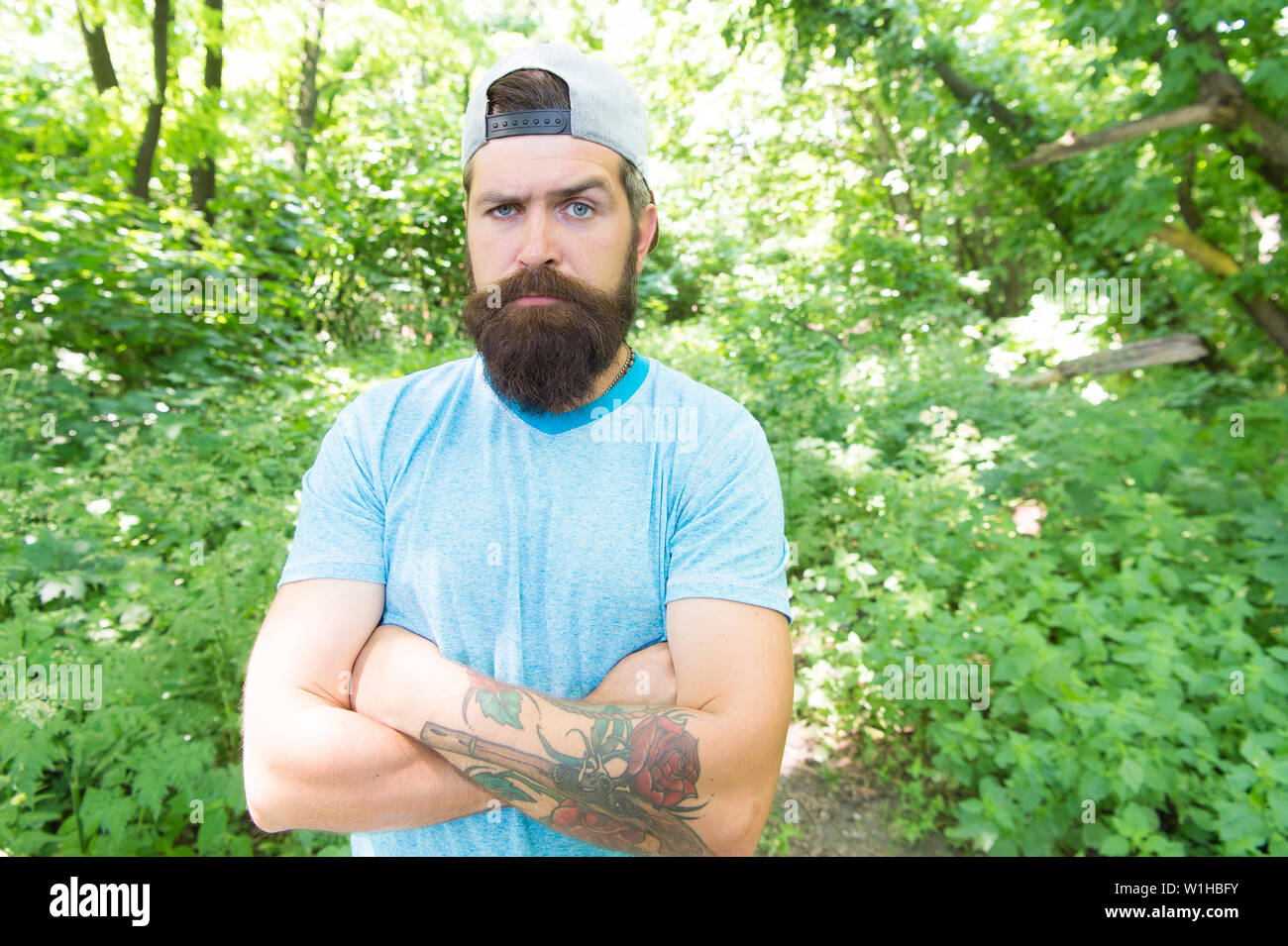 Maschio brutale piacere. Viaggio estivo. Grave barbuto uomo maturo in ambiente naturale. Barbuto ragazzo nella foresta del parco. Barbuto macho. Hipster con barba lunga faccia emotivo da vicino la natura dello sfondo. Foto Stock