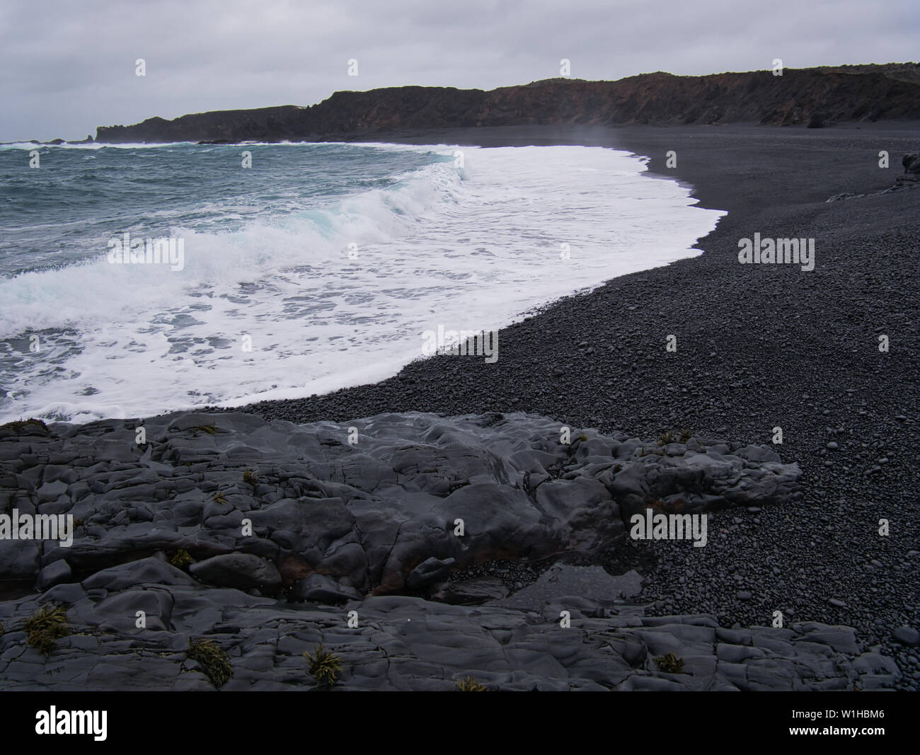 Le onde presso la spiaggia di sabbia nera di Djupalonssandur in Islanda Foto Stock