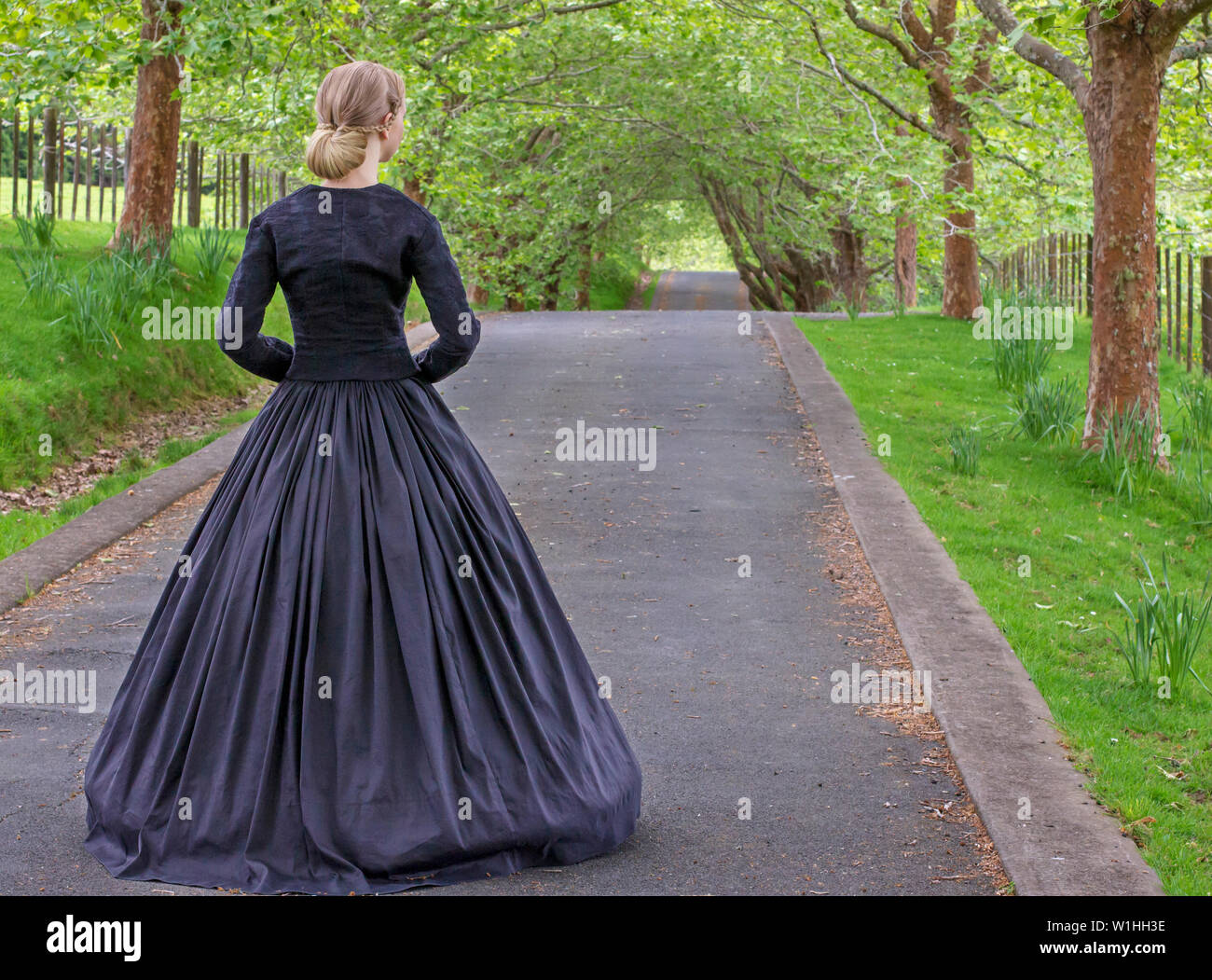 Donna vittoriana in nero ensemble, ombrellone e scialle Foto Stock