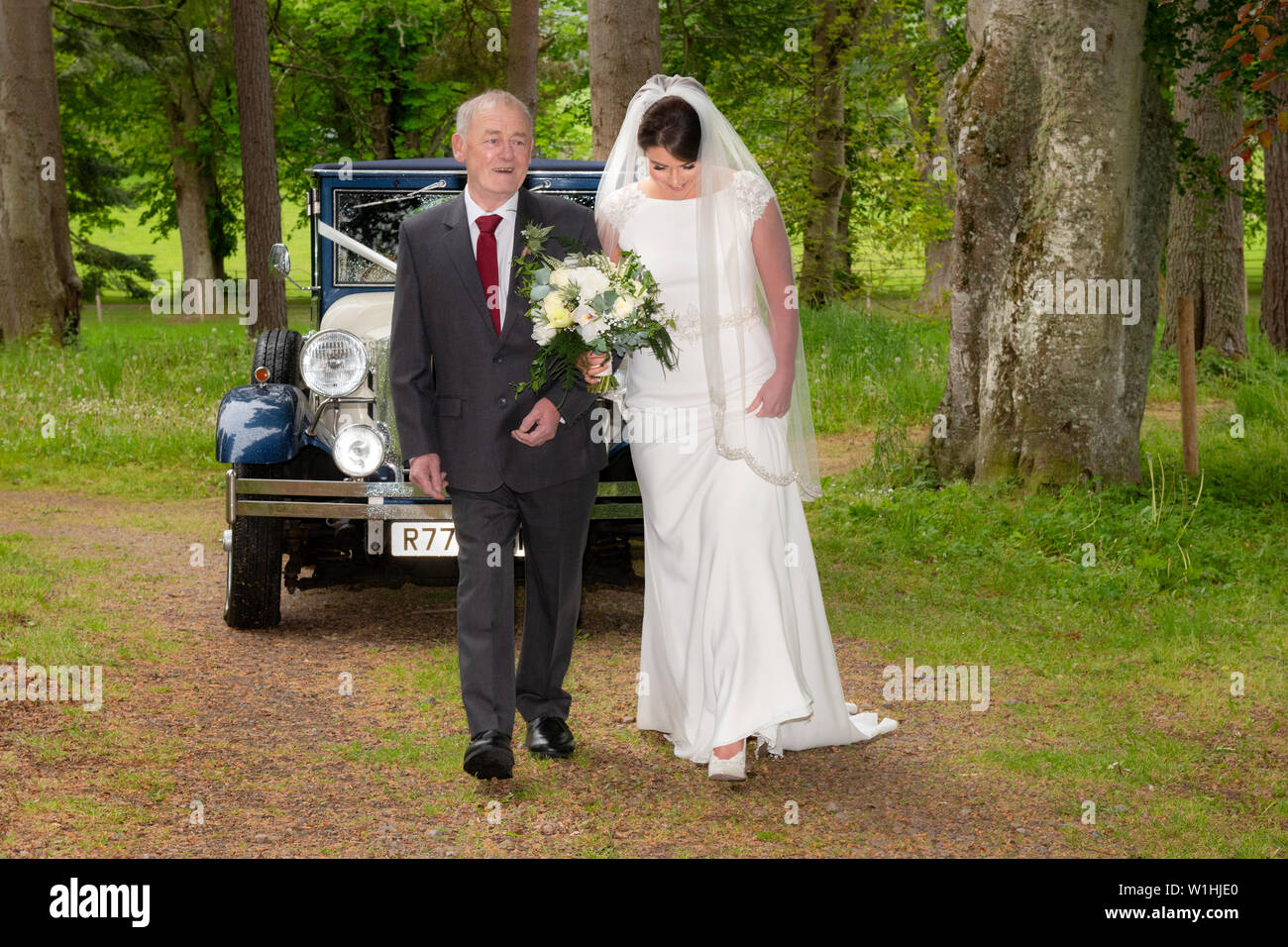 Una sposa e suo nonno da un matrimonio scozzese che ha avuto luogo sul Belladrum station wagon, Kiltarlity, Inverness-shire. Foto Stock