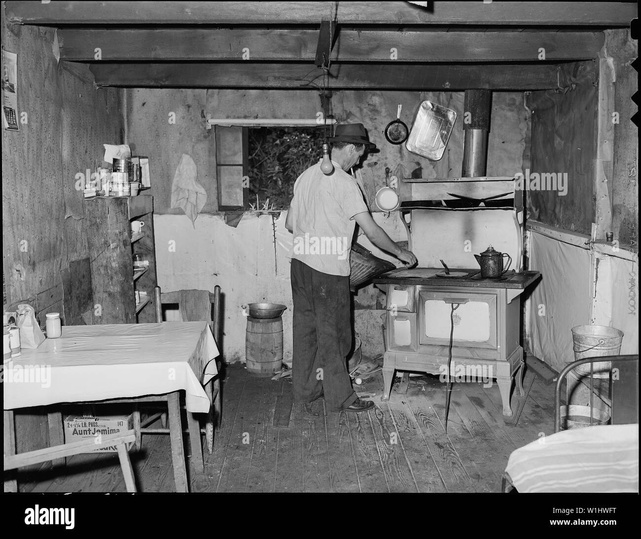 Ray Boggess, un minatore, la costruzione di un incendio in casa sua in azienda progetto di alloggiamento. Questa camera, convertito garage, affitti per $5.30 mensile. Io sono un shanty carbone uomo, egli dice. Non fumogeno Mullens Coal Company, Mullens miniera, Mullens, Wyoming County, West Virginia. Foto Stock