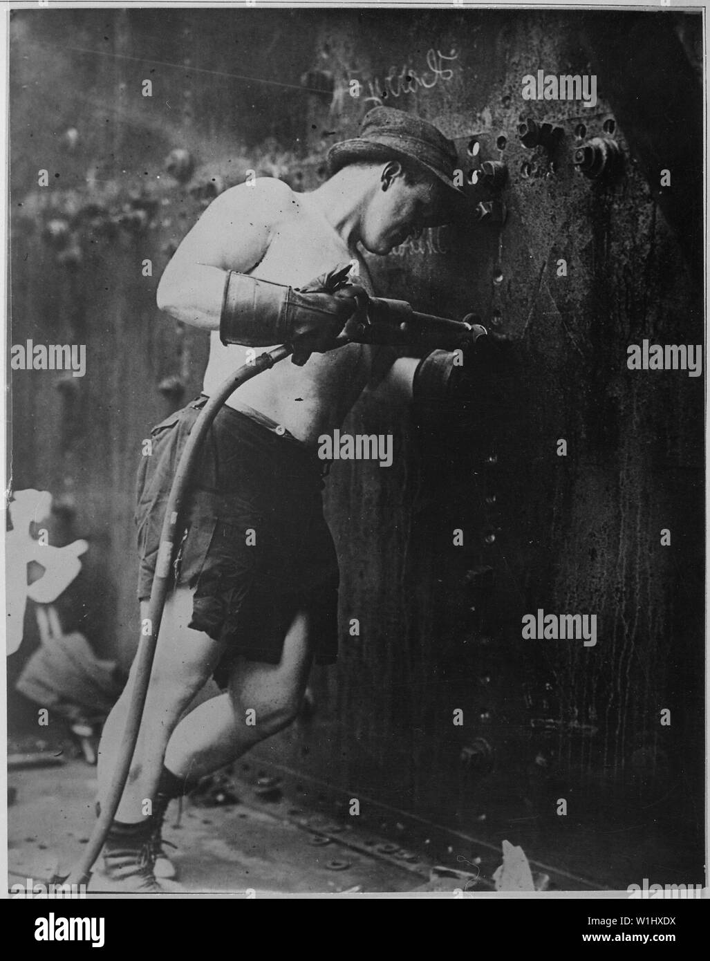 Rivettatrice a lavorare a Hog Island cantiere navale. In Pennsylvania, 1918. Kadel & Herbert., 1917 - 1919; Note Generali: Utilizzo di guerra e di conflitto numero 534 quando si ordina una riproduzione o la richiesta di informazioni su questa immagine. Foto Stock