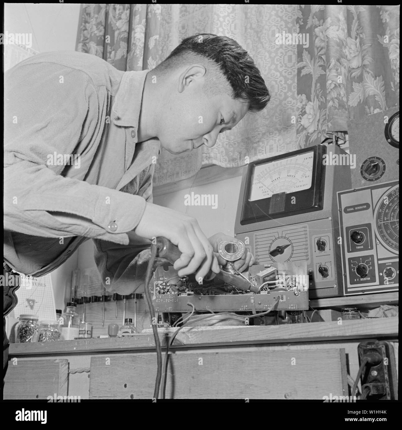 Rohwer Relocation Center, McGehee, Arkansas. John K. Matsuhiro, un ex California servizio radio m . . .; Portata e contenuto: tutta la didascalia per questa fotografia si legge: Rohwer Relocation Center, McGehee, Arkansas. John K. Matsuhiro, un ex California servizio radio uomo, svolge la sua attività presso il Centro Rohwer, dove, nonostante le difficoltà nel garantire la riparazione parti, John è stato in grado di conservare molti centro radio funzionante. Lavoratori qualificati, di quasi ogni tipo, si trovano tra il centro residenti, ex west coast persone di ascendenza giapponese. Foto Stock