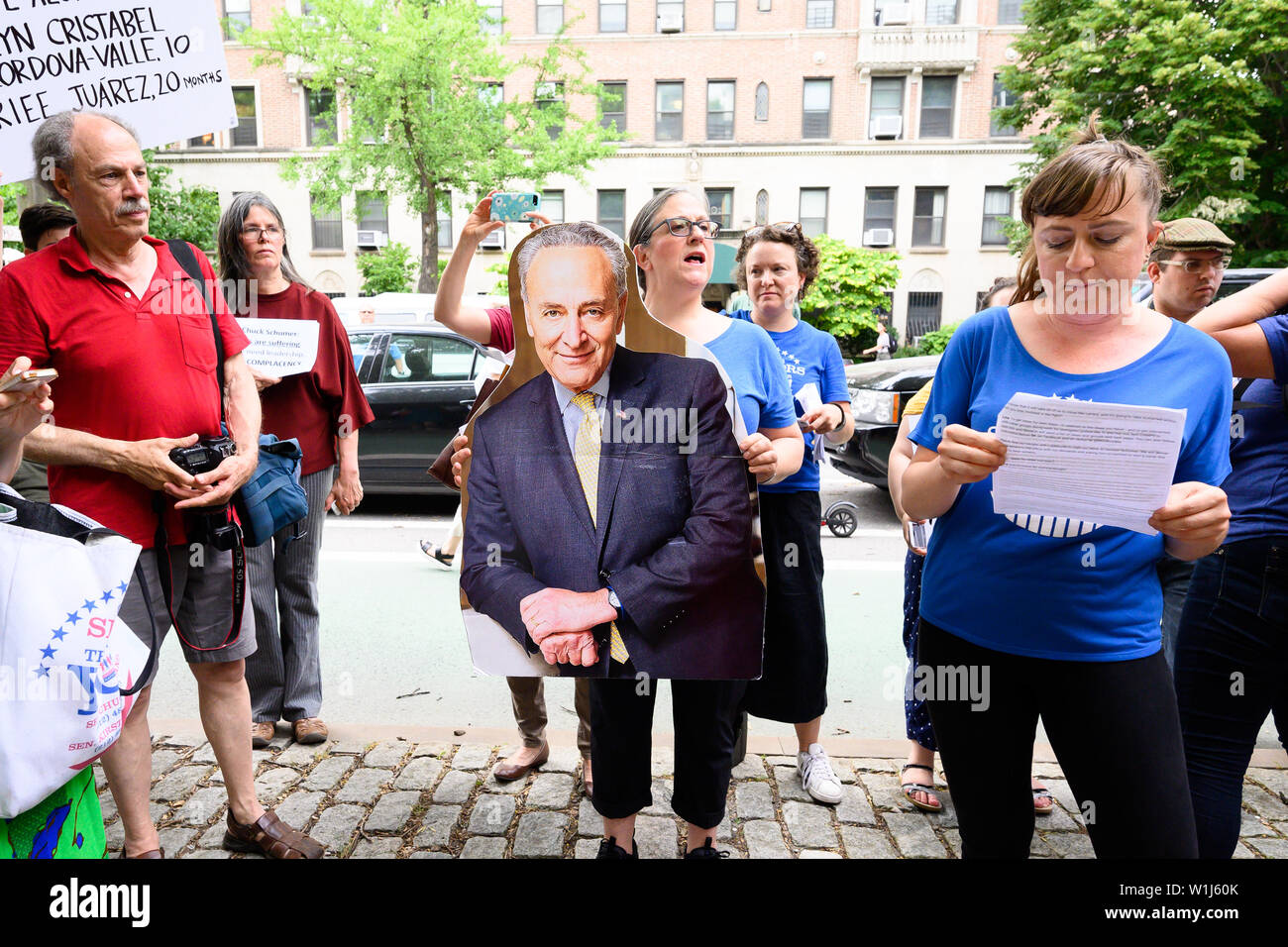 Brooklyn, Stati Uniti. 02Luglio, 2019. Una donna che tiene un cartello del senatore Chuck Schumer dimensione di vita durante una manifestazione di protesta per la chiusura dei migranti nei campi profughi nel sud del confine. "Chiudere i campi" Rally di avvocato per la chiusura dei campi dove i migranti alla frontiera meridionale sono detenuti. Il rally si è svolta di fronte al appartamento dove il senatore Chuck Schumer (D-NY) vive a Brooklyn, New York. Credito: SOPA Immagini limitata/Alamy Live News Foto Stock