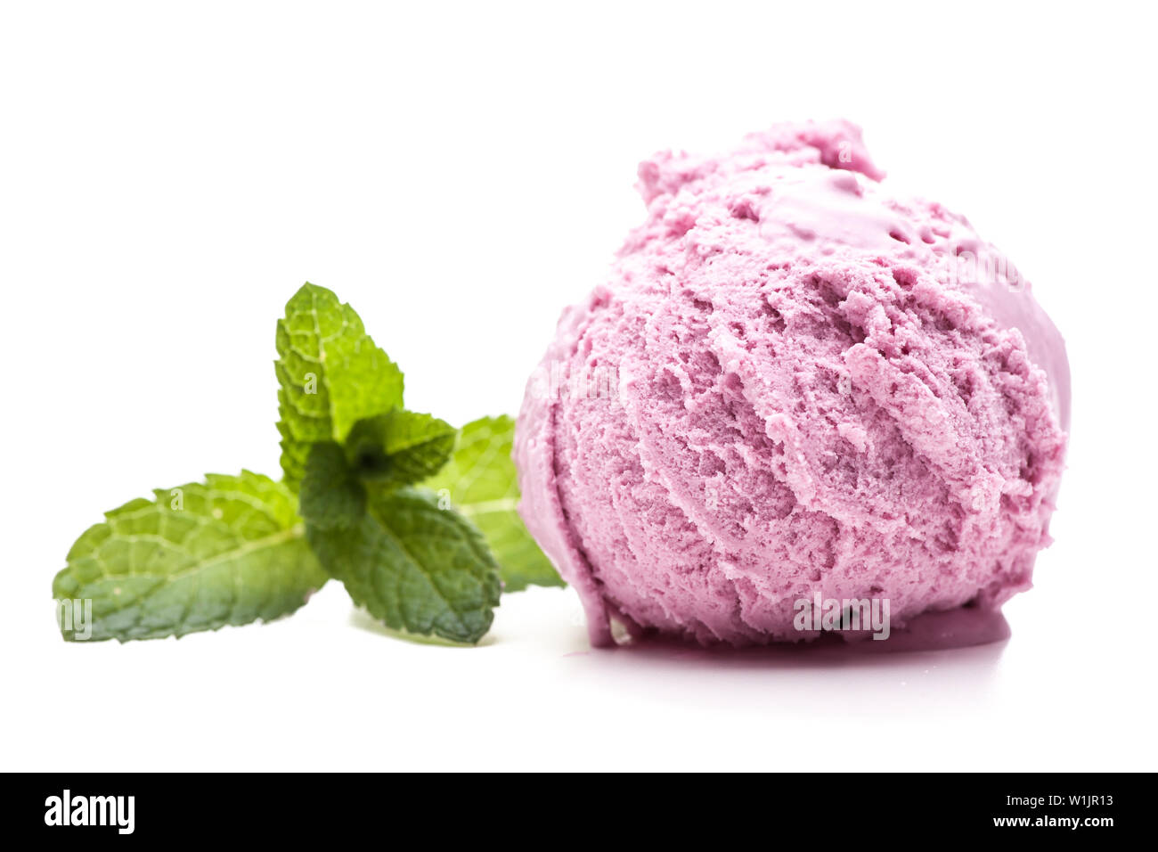 Una pallina di gelato al lampone con una foglia di menta isolati su sfondo bianco Foto Stock