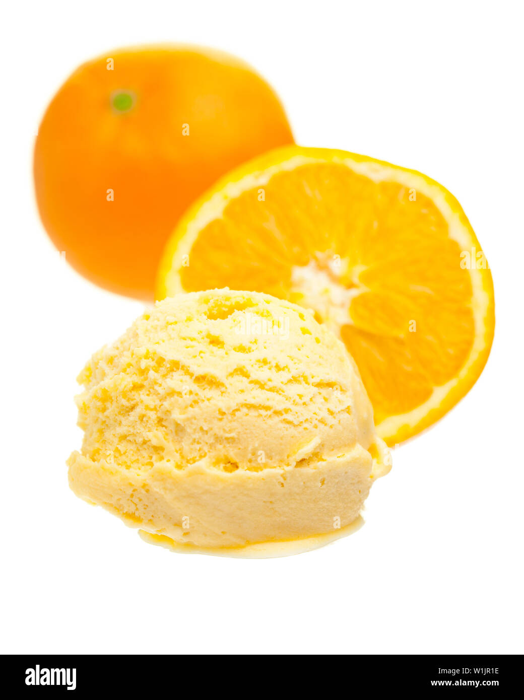 Orange ice cream scoop nella parte anteriore delle arance su sfondo bianco Foto Stock