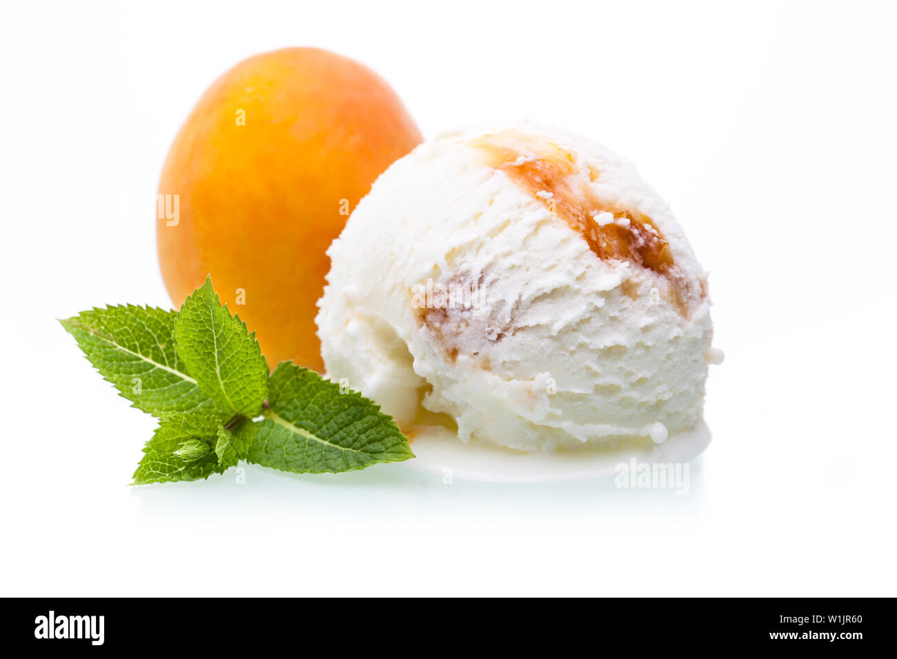 Un cucchiaio di Albicocca gelato di fronte una albicocca Foto Stock