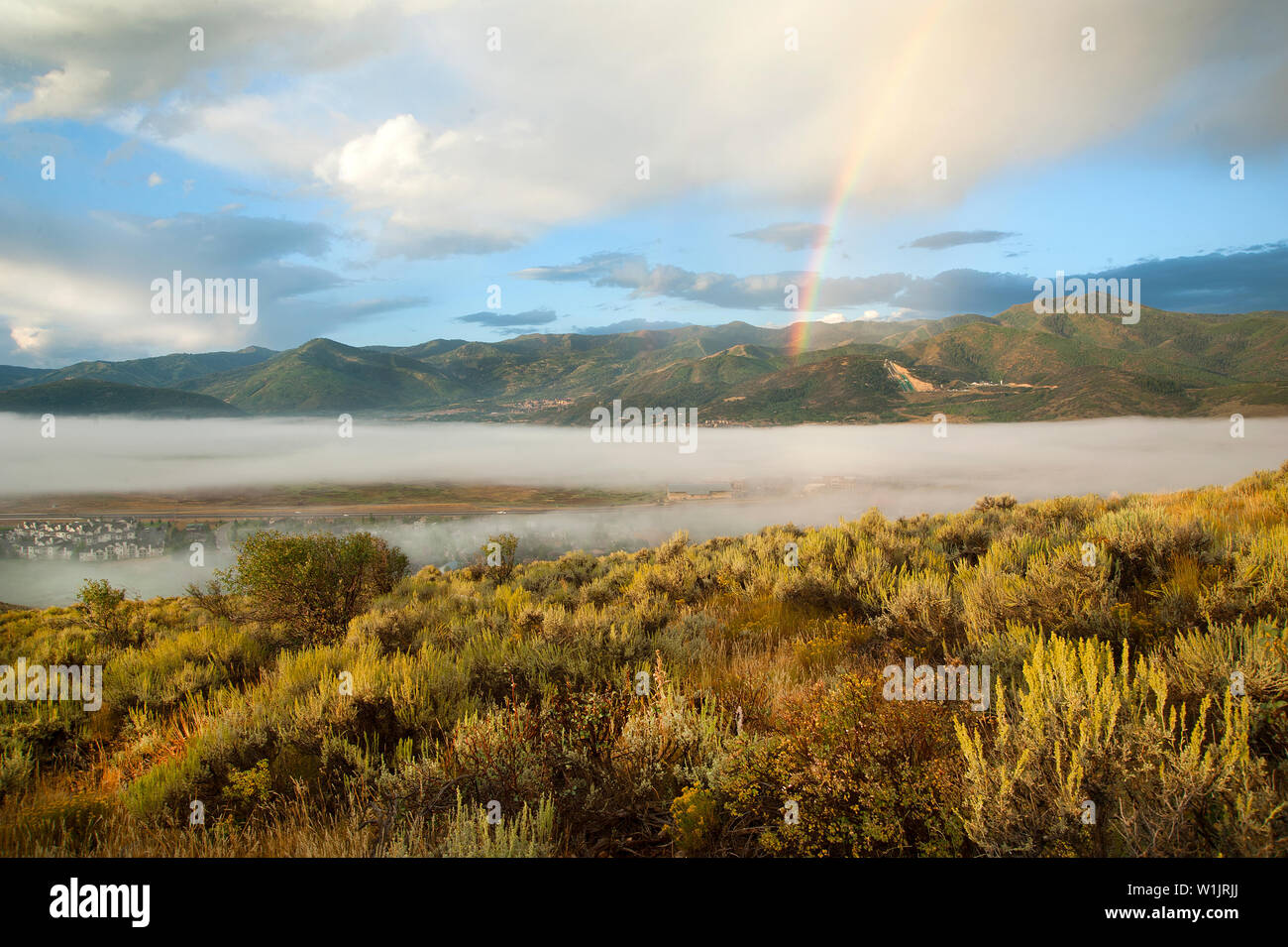 Un arcobaleno perfora il cielo mattutino come nebbia lentamente si solleva dal suolo desertico di Park City, Utah. (C) 2013 Tom Kelly Foto Stock