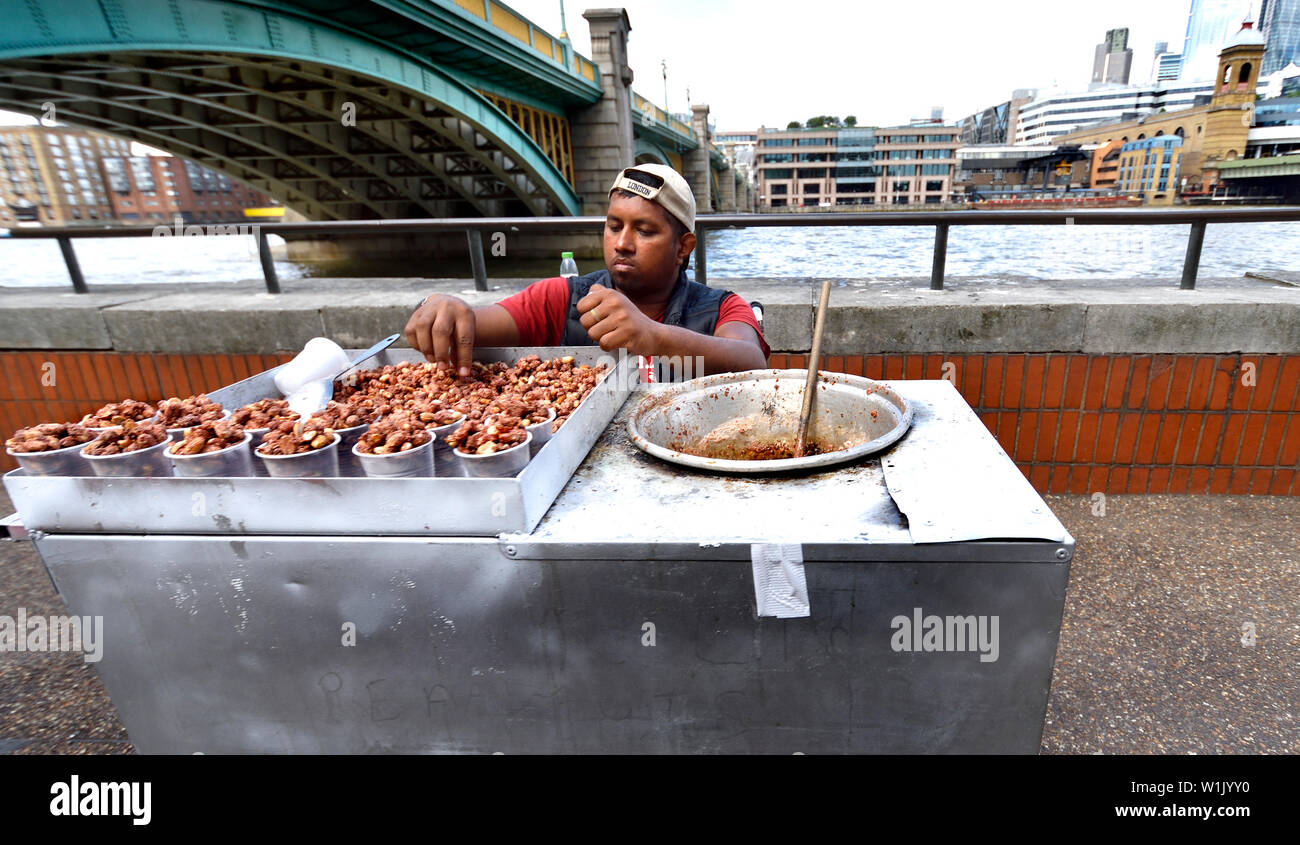Londra, Inghilterra, Regno Unito. Uomo di vendita dadi caramellato sulla South Bank, Southwark Foto Stock Londra, Inghilterra, Regno Unito. Uomo di vendita dadi caramellato sulla South Bank, Southwark Foto Stock