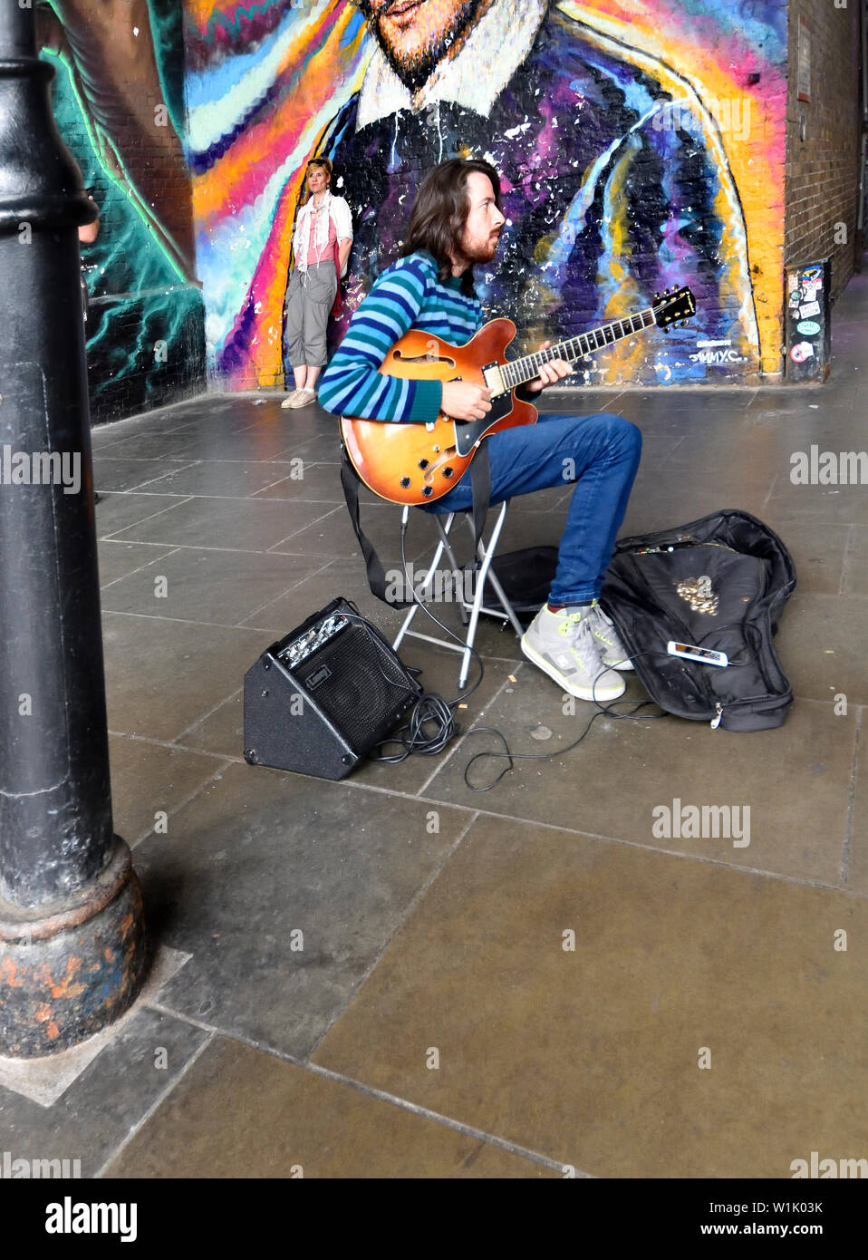 Londra, Inghilterra, Regno Unito. Busker suonare la chitarra davanti a un  murale in Southwark - le persone che hanno preso una foto in background  Foto stock - Alamy