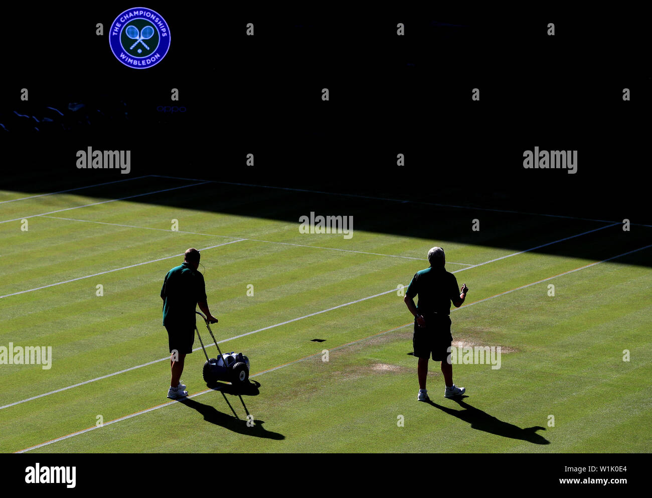 Il personale del Ground prepara il campo del centro prima del terzo giorno del Wimbledon Championships presso l'All England Lawn Tennis and Croquet Club, Wimbledon. Foto Stock