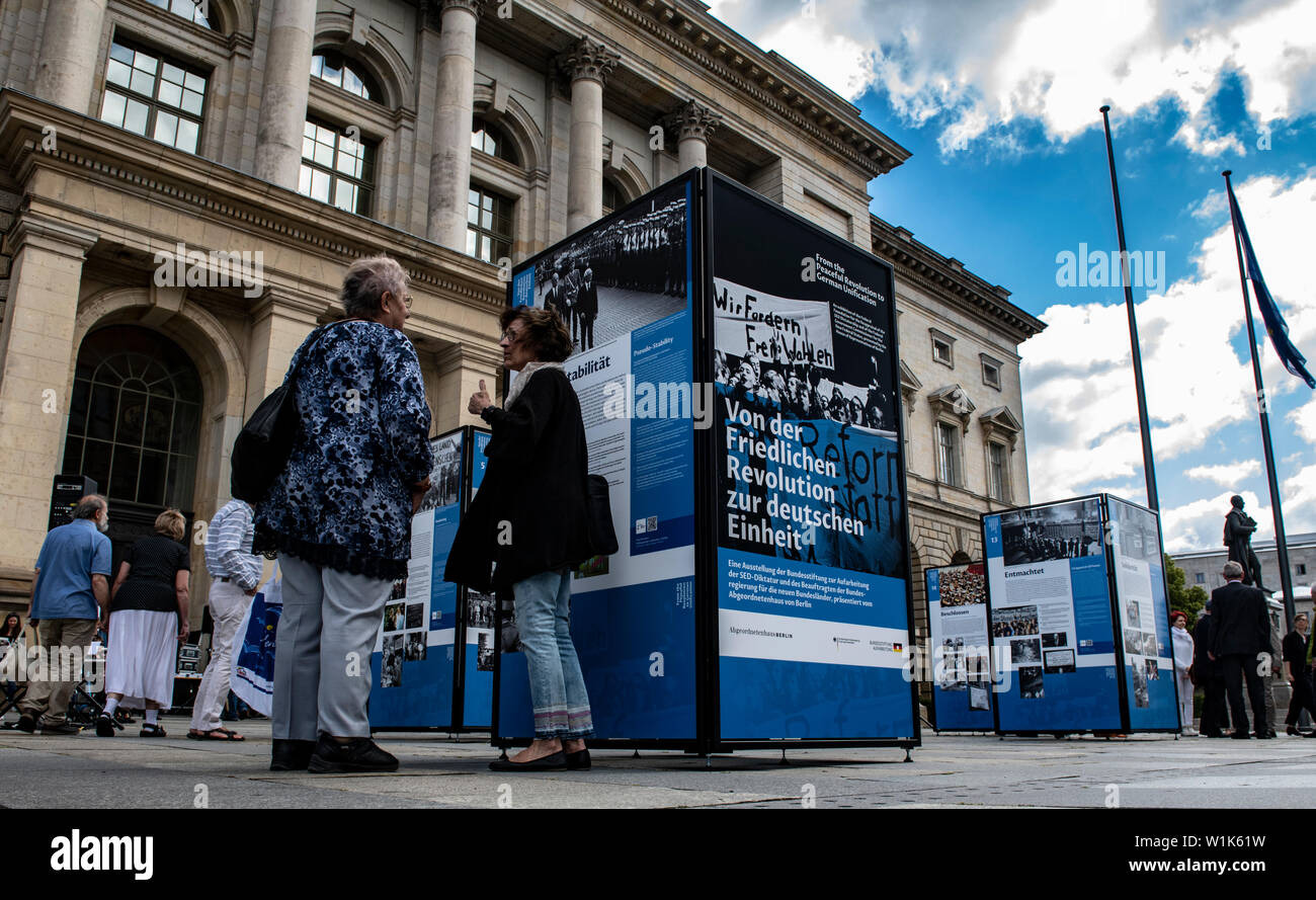 Berlino, Germania. 03 Luglio, 2019. Le persone sono in piedi di fronte a pannelli informativi presso la Casa dei Rappresentanti. Essi fanno parte del nuovo open-air mostra 'dalla rivoluzione pacifica all'Unità tedesca", organizzato dall'Bundesstiftung zur Aufarbeitung der SED-Diktatur. L'occasione per la presentazione è il prossimo trentesimo anniversario della caduta del muro di Berlino. Credito: Paolo Zinken/dpa/Alamy Live News Foto Stock