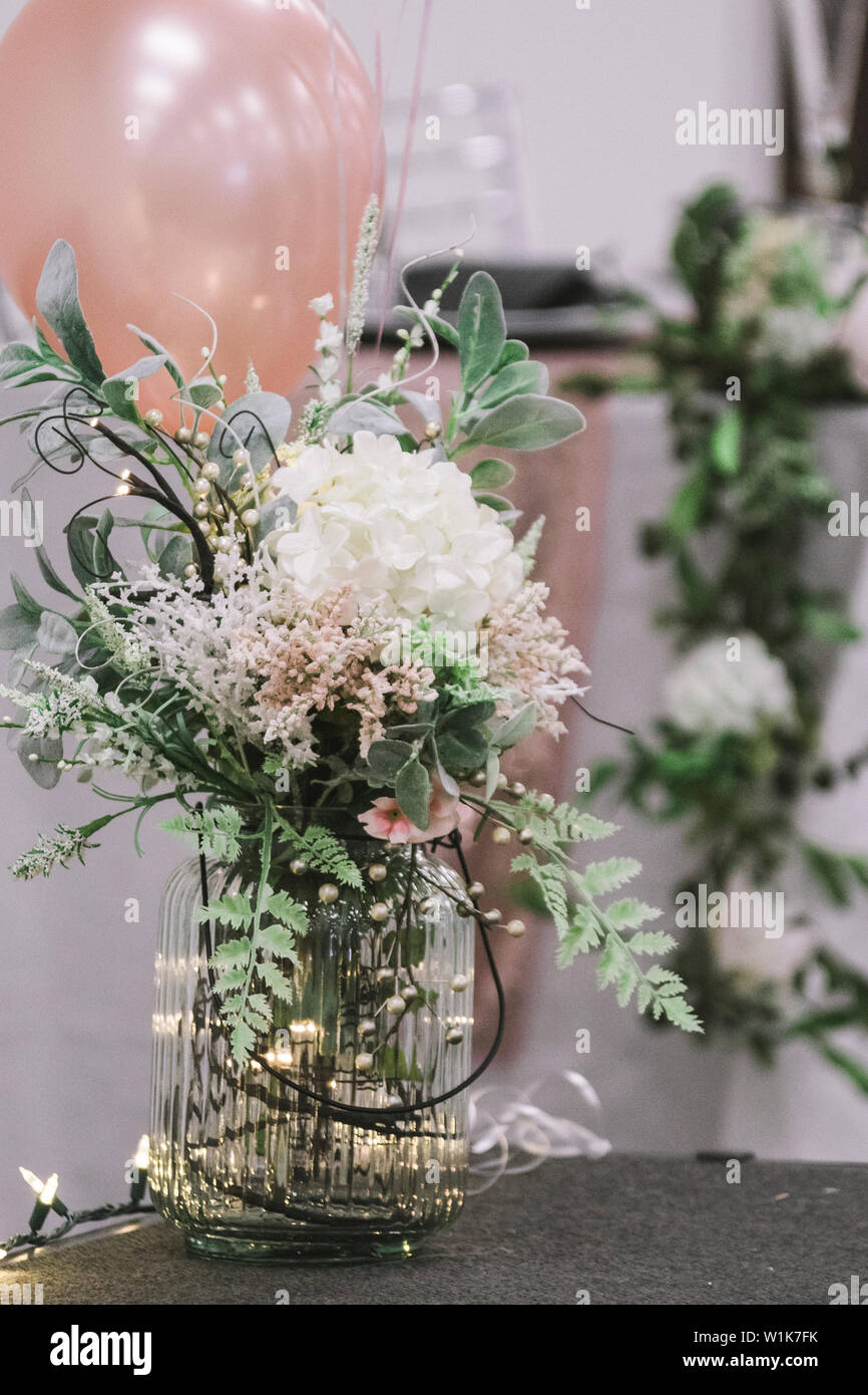 Una sfera mason Vaso con fiori di colore bianco e le luci fairy Foto Stock