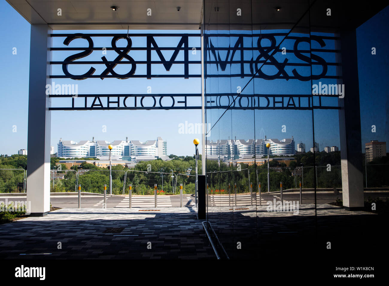 BIRMINGHAM, Regno Unito - Luglio 03, 2019: Vista della Queen Elizabeth Hospital Birmingham da Selly Oak Retail Park con Mark Spencer e firmare in primo piano Foto Stock