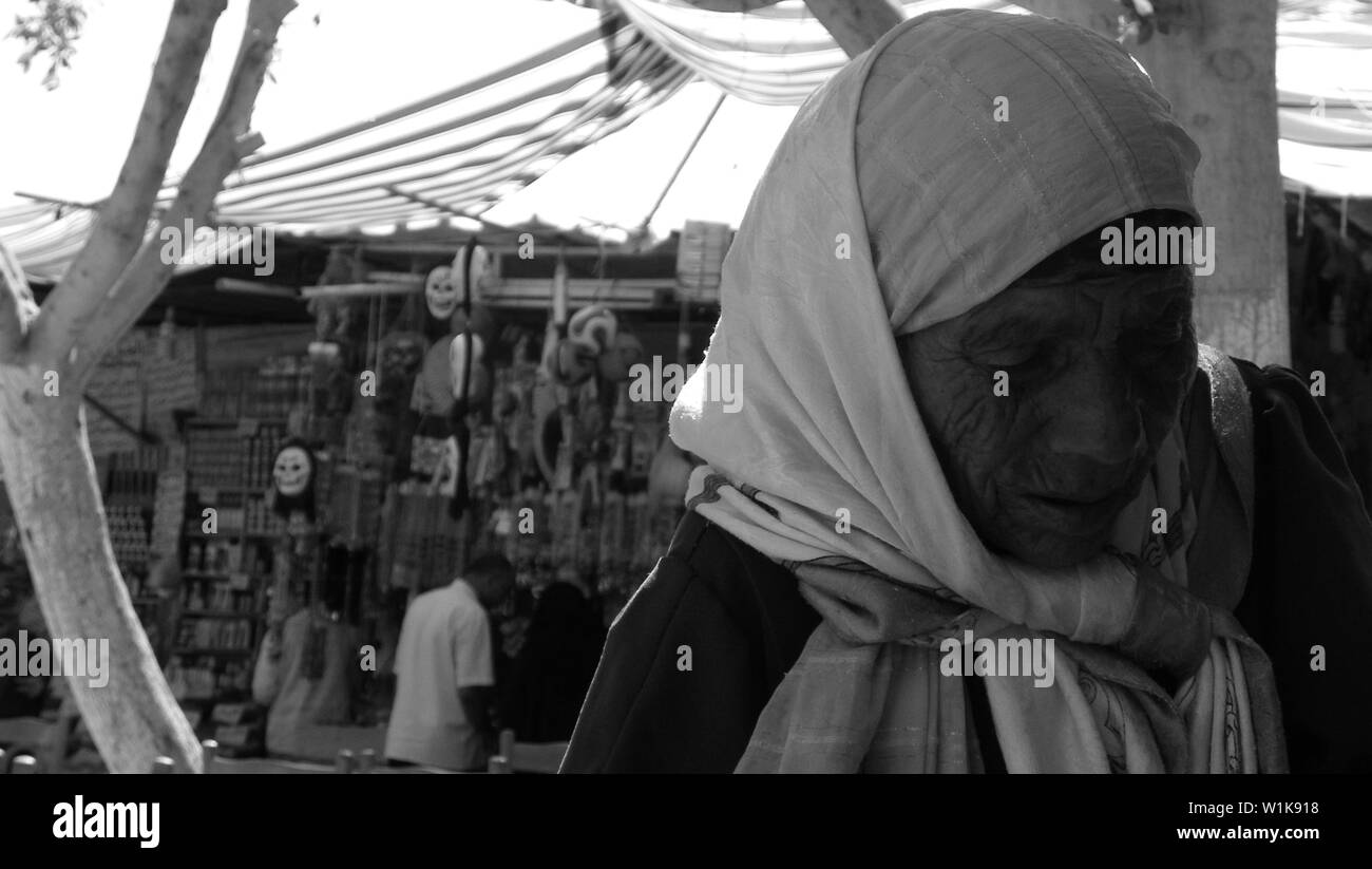 Una foto in bianco e nero per una vecchia donna vendita di quotidiani a Marsa Matrouh, Egitto Foto Stock