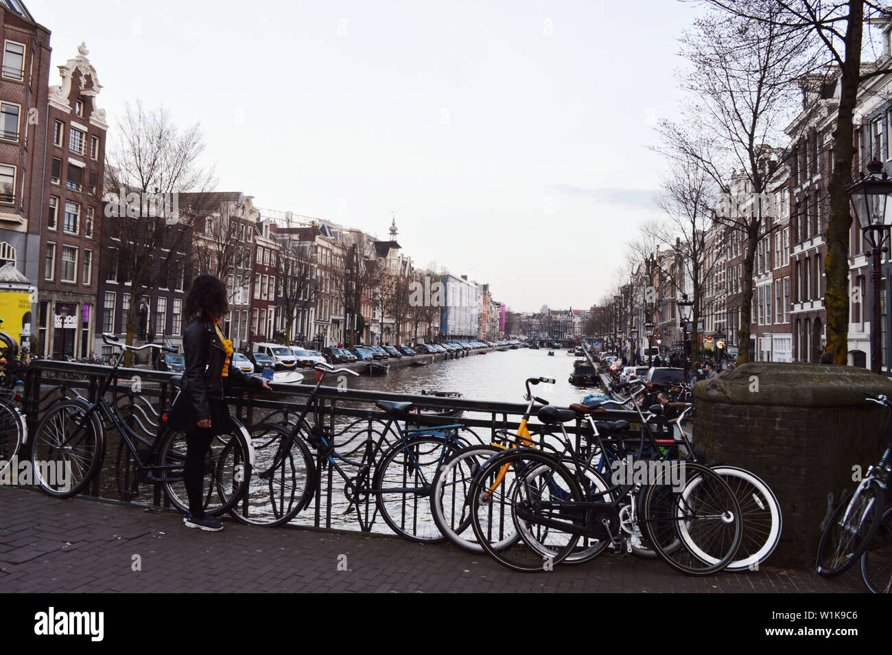 Una giovane donna è guardando Canal a Amsterdam, Paesi Bassi Foto Stock