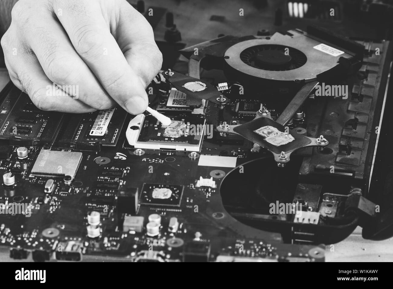 Maykop, Russia - 16 Settembre 2016: uomo master la riparazione di un computer rende la sostituzione della pasta termica sui processori per notebook, foto in bianco e nero Foto Stock