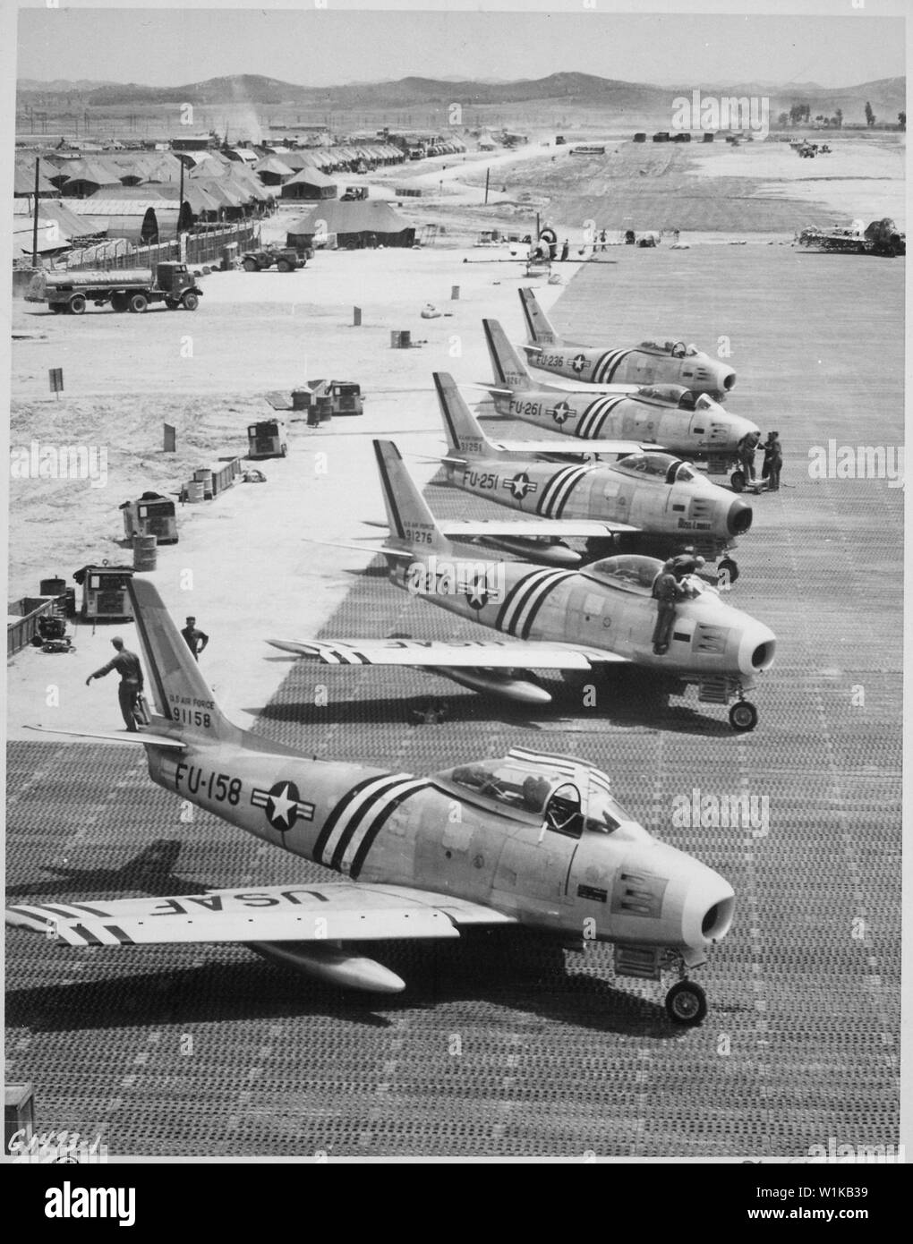 Vista del F-86 aerei sulla linea di volo ottenere pronto per il combattimento. Air Force.; Note Generali: Cinque North American F-86un Sabre combattenti del 4° Fighter Interceptor ala sulla linea di volo a Suwon, Corea del Sud nel giugno 1951. La F-86come sono state F-86A-5-NA: 49-1158 è stata danneggiata da un MiG-15 il 23 settembre 1951; 49-1276 del 336a FIS è stato abbattuto da un MiG-15 il 22 giugno 1951; 49-1251, 49-1261, 49-1236 del 334 FIS è stato abbattuto da un MiG-15 il 24 ottobre 1951. Usare la guerra e il conflitto numero 1413 quando si ordina una riproduzione o la richiesta di informazioni su questa immagine. Foto Stock