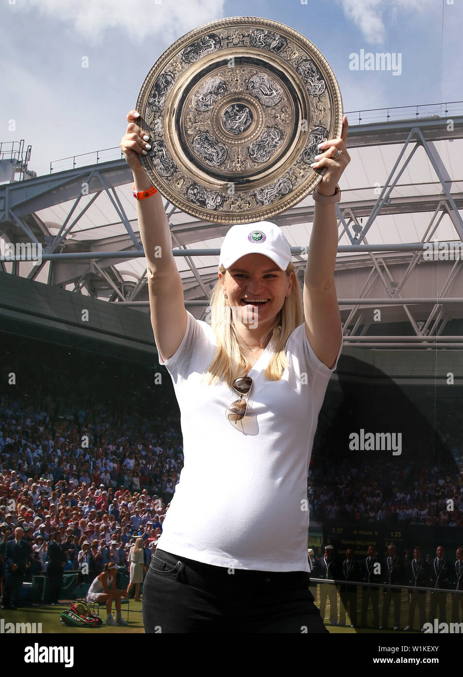 Gli spettatori posano con tagli di cartone dei trofei all'inizio del terzo giorno del Wimbledon Championships presso l'All England Lawn Tennis and Croquet Club di Londra. Foto Stock