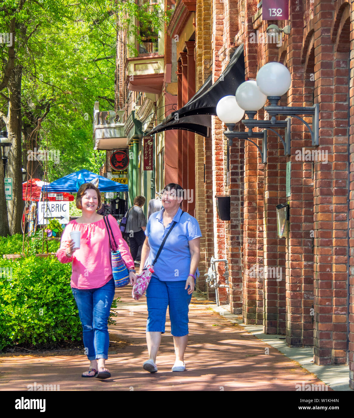 Due femmina quilters camminando lungo la casa mercato piazza durante la settimana del Quilt 2019 Paducah Kentucky negli Stati Uniti. Foto Stock