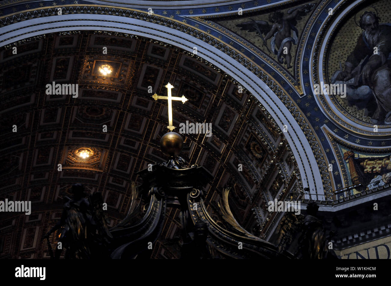 Una croce in oro si staglia contro il soffitto della Basilica di San Pietro in Vaticano. Foto Stock