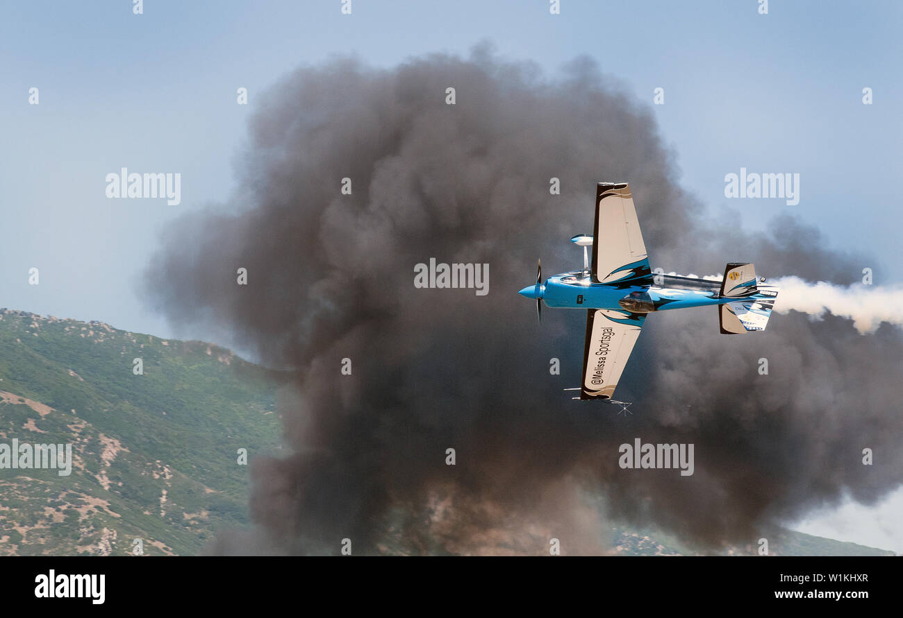 Uno del mondo più diversi atleti elite, Melissa Pemberton, coltelli il suo bordo 540 aerei attraverso denso fumo nero da un display pyro a W Foto Stock