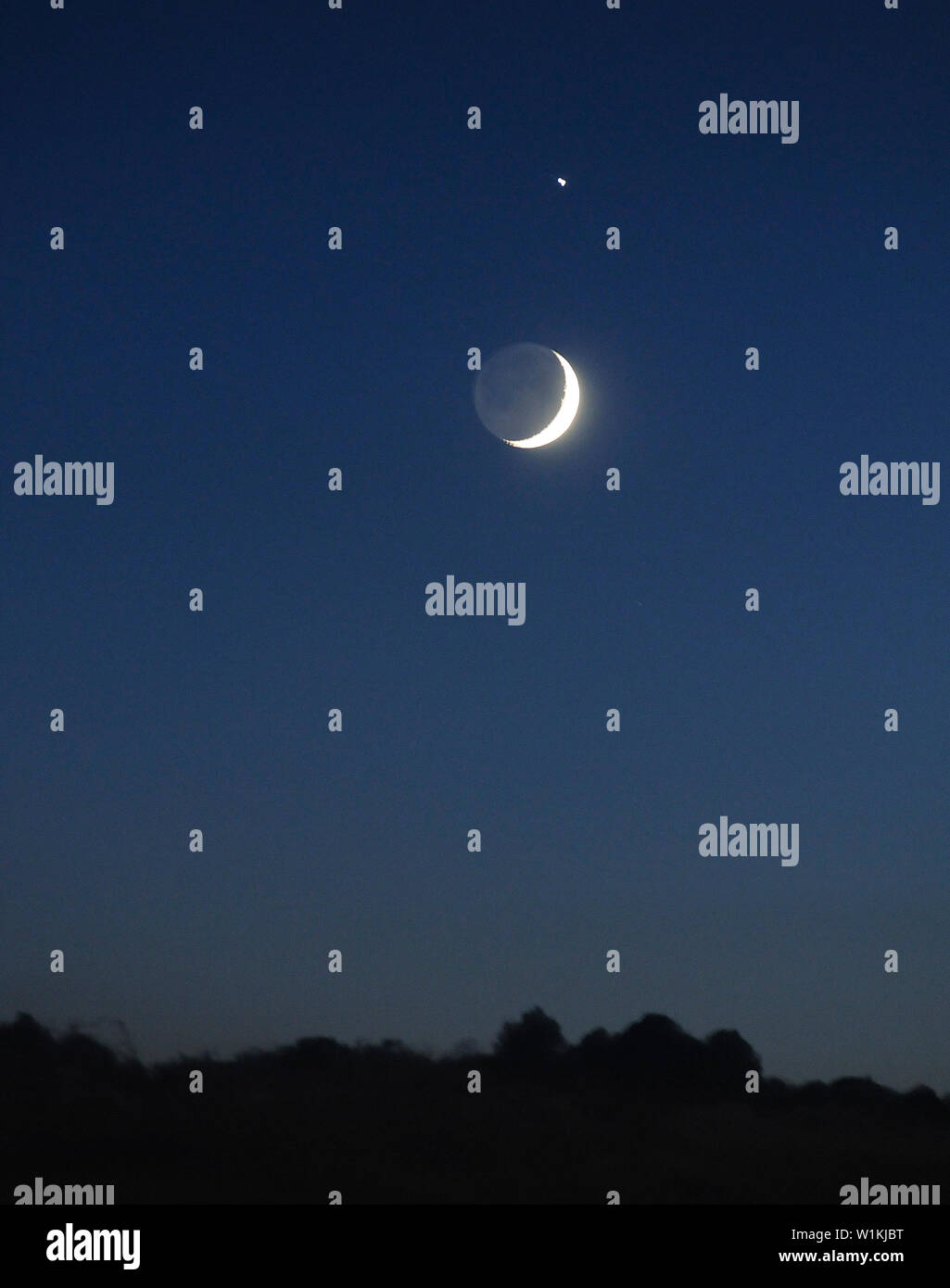 Giove sorge alto nel cielo occidentale al di sopra della luna sopra un banco di nuvole sopra il Wasatch Range di montagna vicino a Park City, Utah. (C) 2016 Tom Kelly Foto Stock