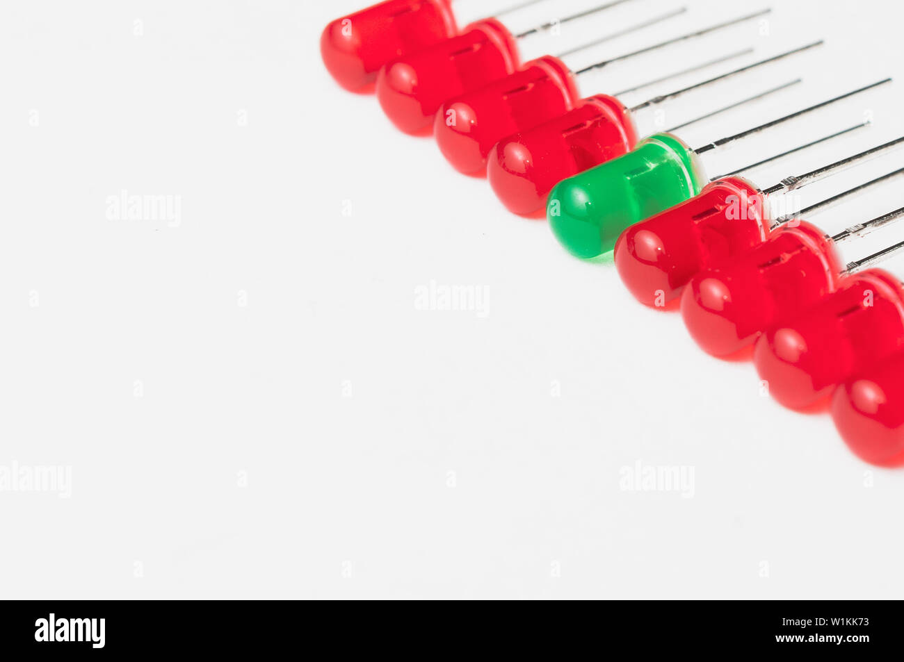Essere diversi e stare fuori dalla folla del concetto: un LED verde tra otto quelli rossi. Sfondo bianco e un sacco di spazio copia. Foto Stock